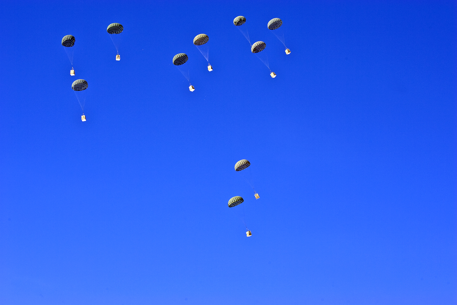 Parachutes in blue sky.