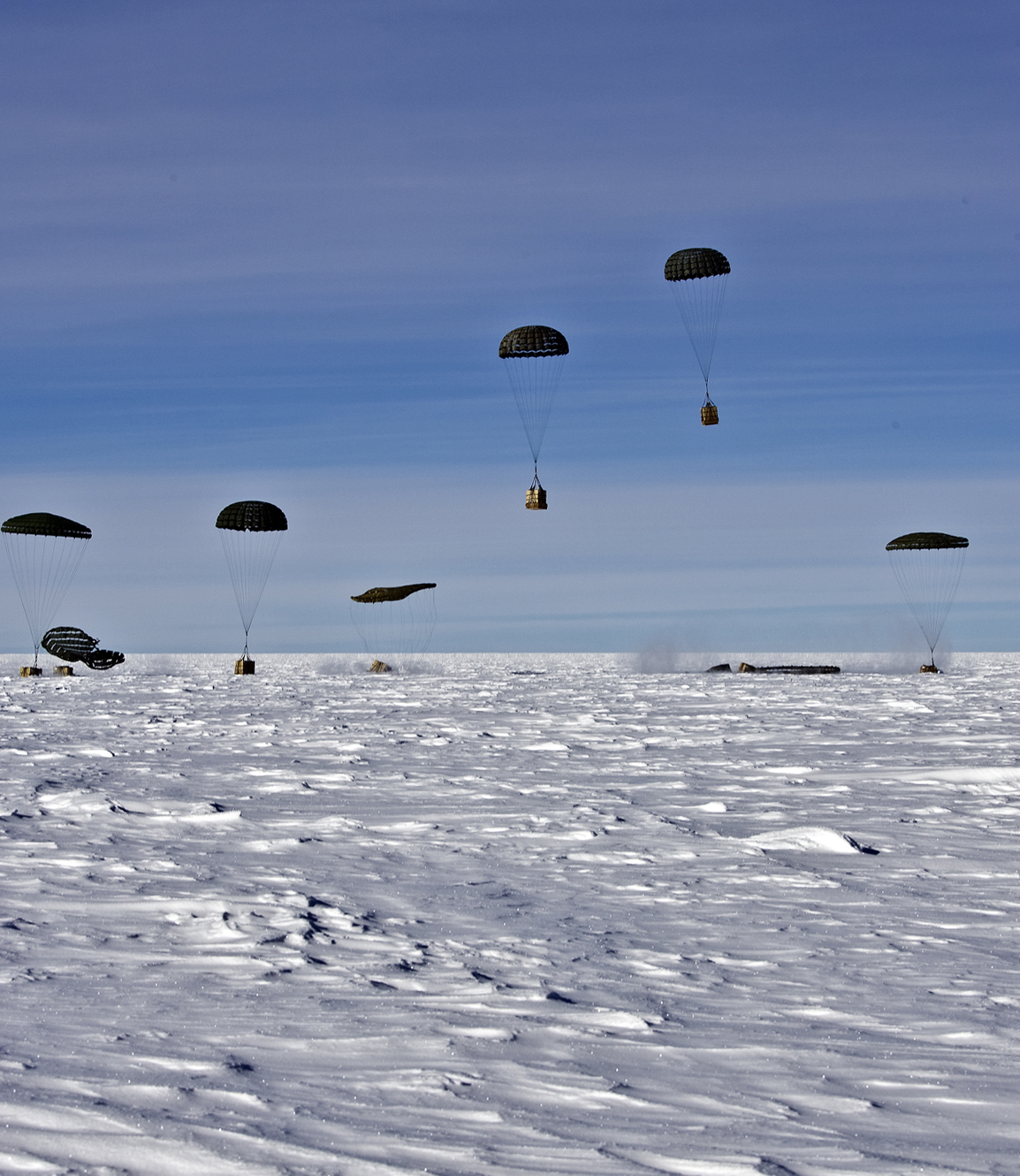 Parachutes landing on snow.