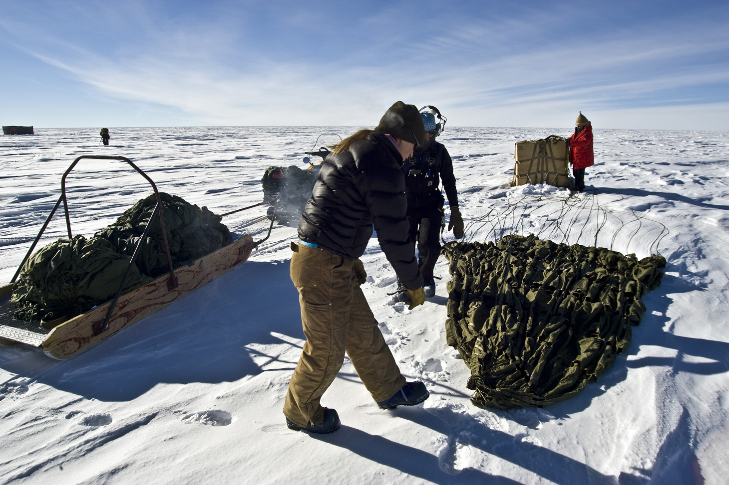 People retrieve cargo in snow.