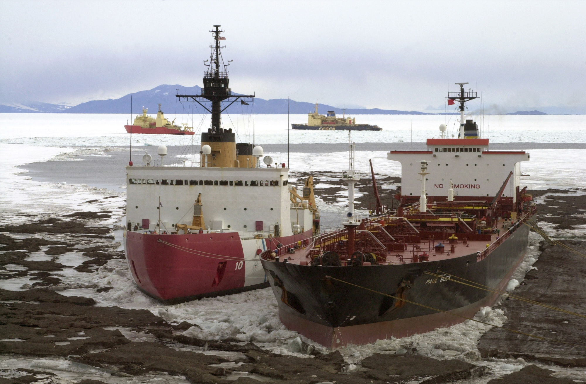 Four large ships in icy water.