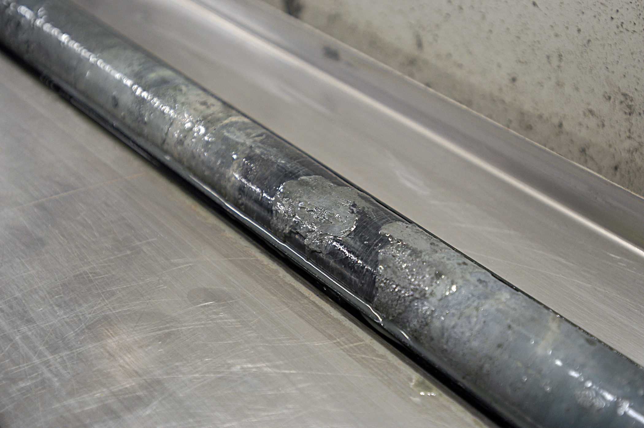 Sediment core sits on a metal table.