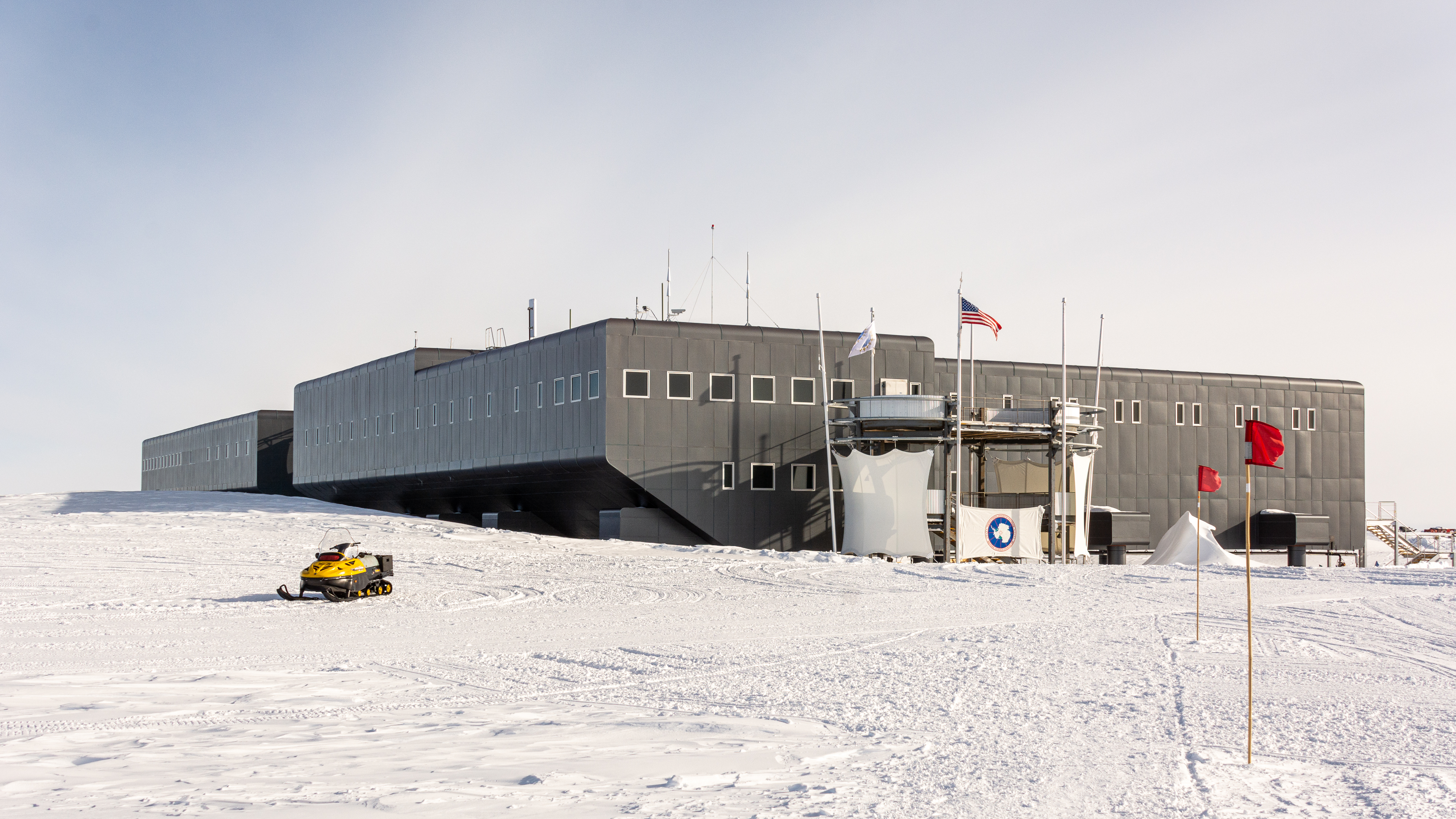 A large building on a flat snowy landscape.