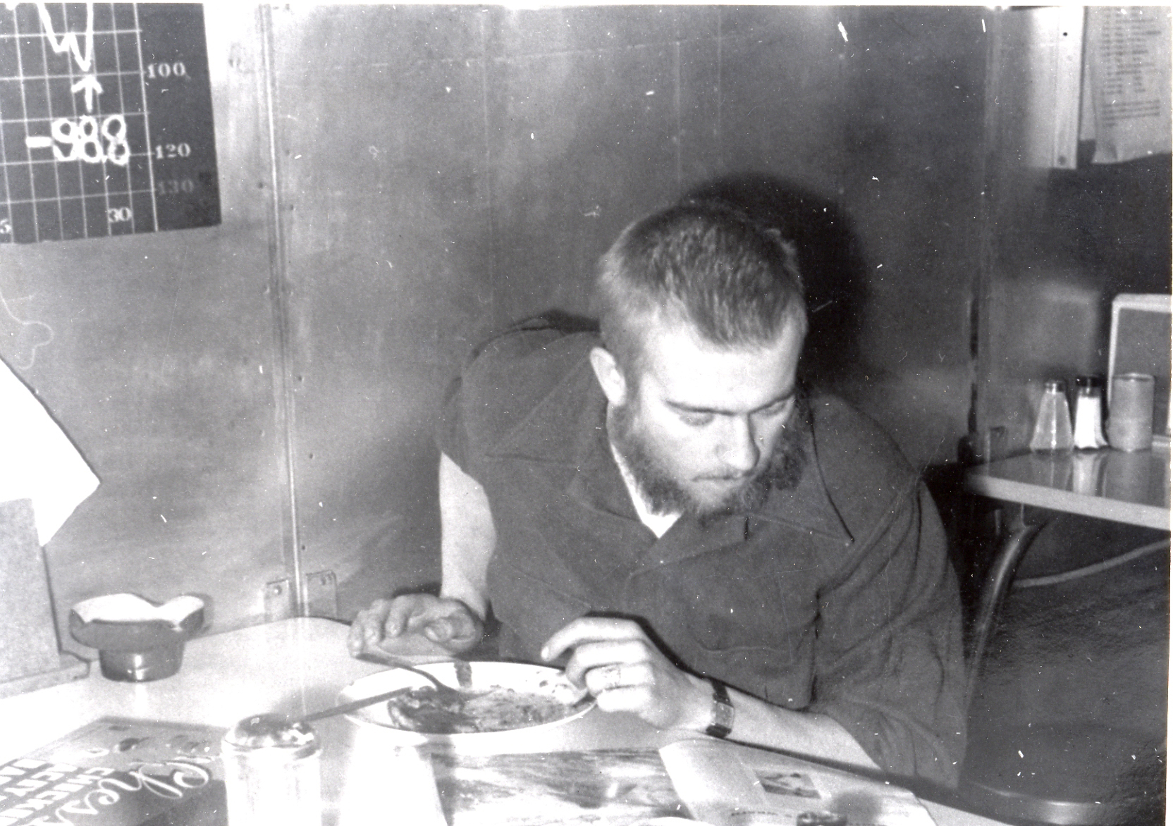 Man reads while eating a meal.