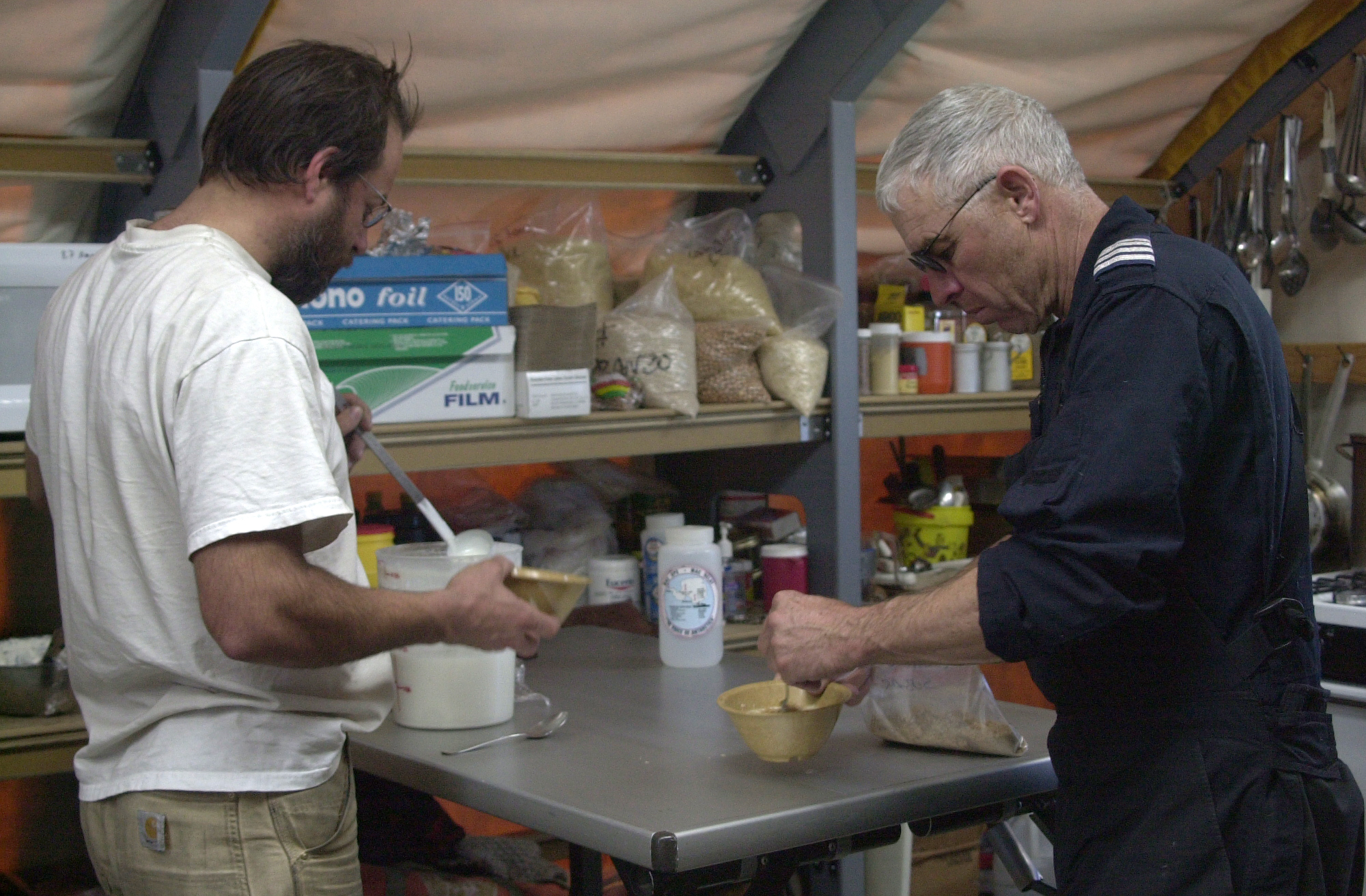 Two men make themselves breakfast.