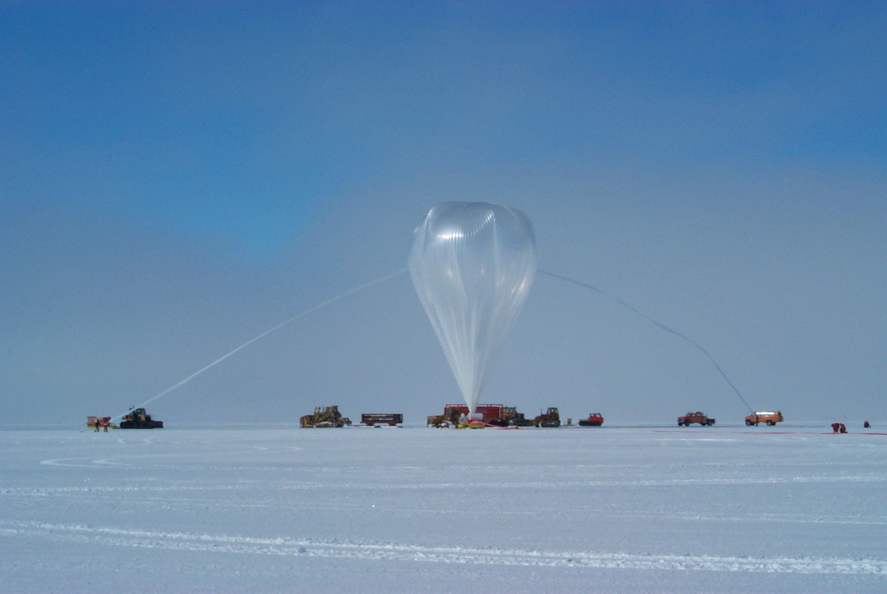 On the distant horizon an enormous balloon inflates upward.