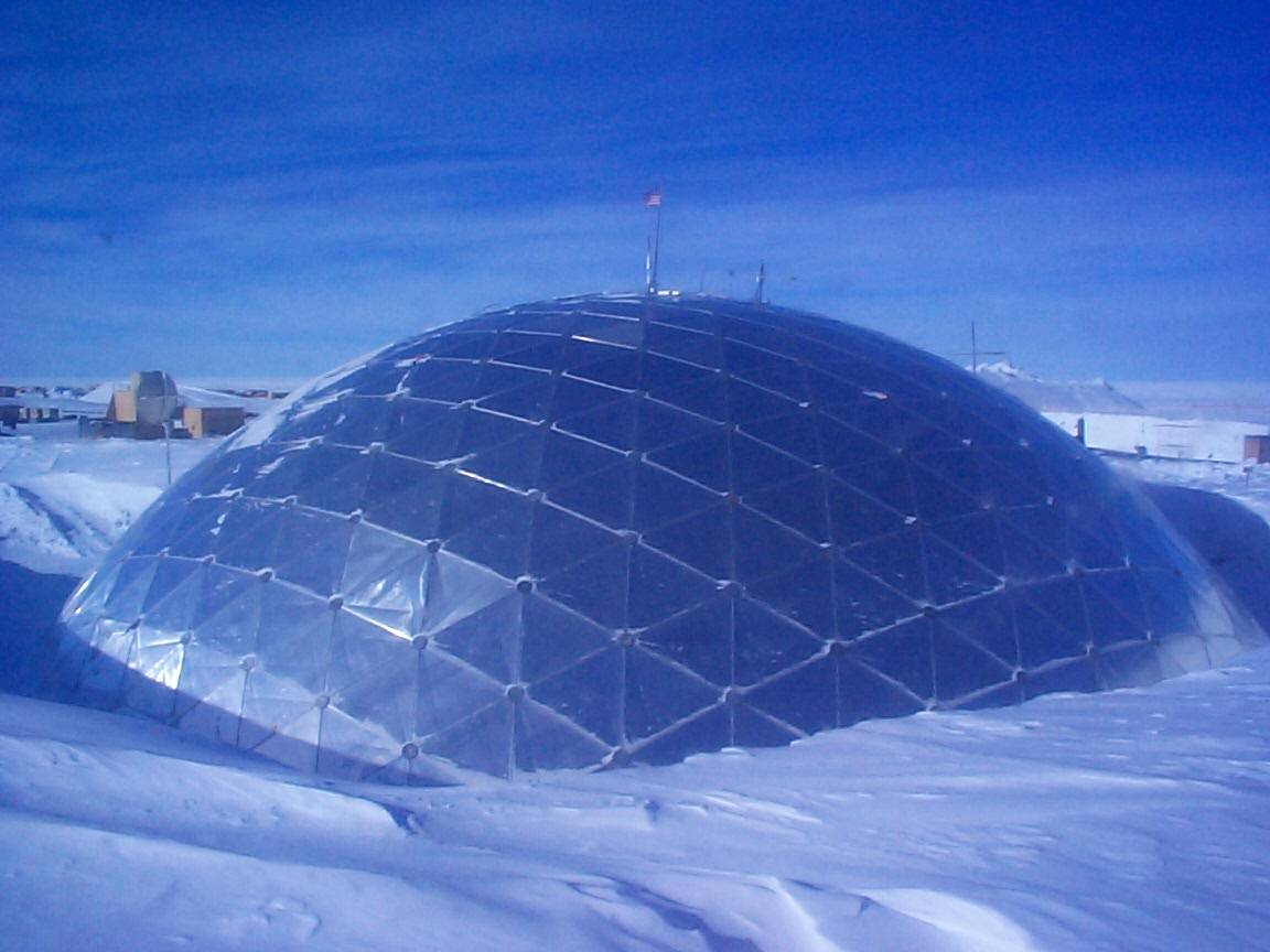 A large metal geodesic dome, surrounded by snow.