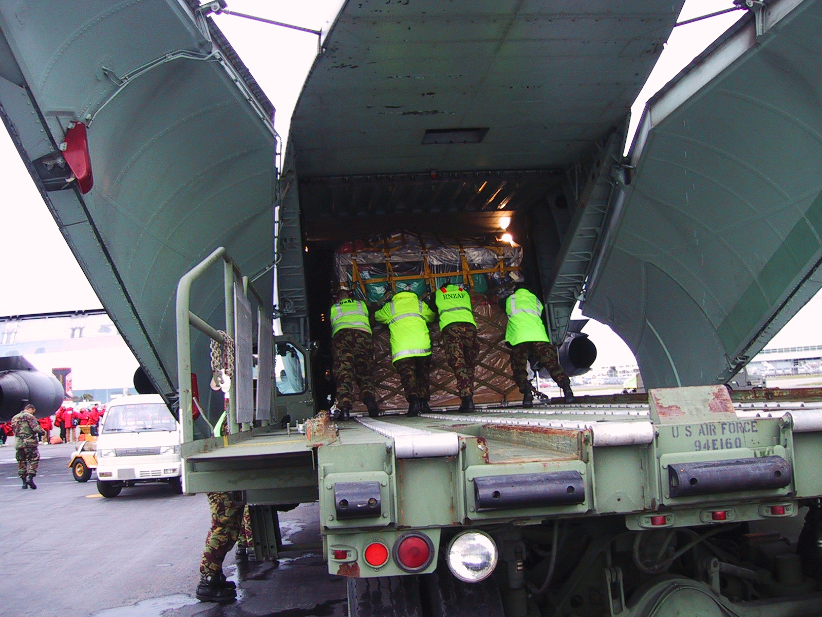 Soldiers load cargo onto a military aircraft.