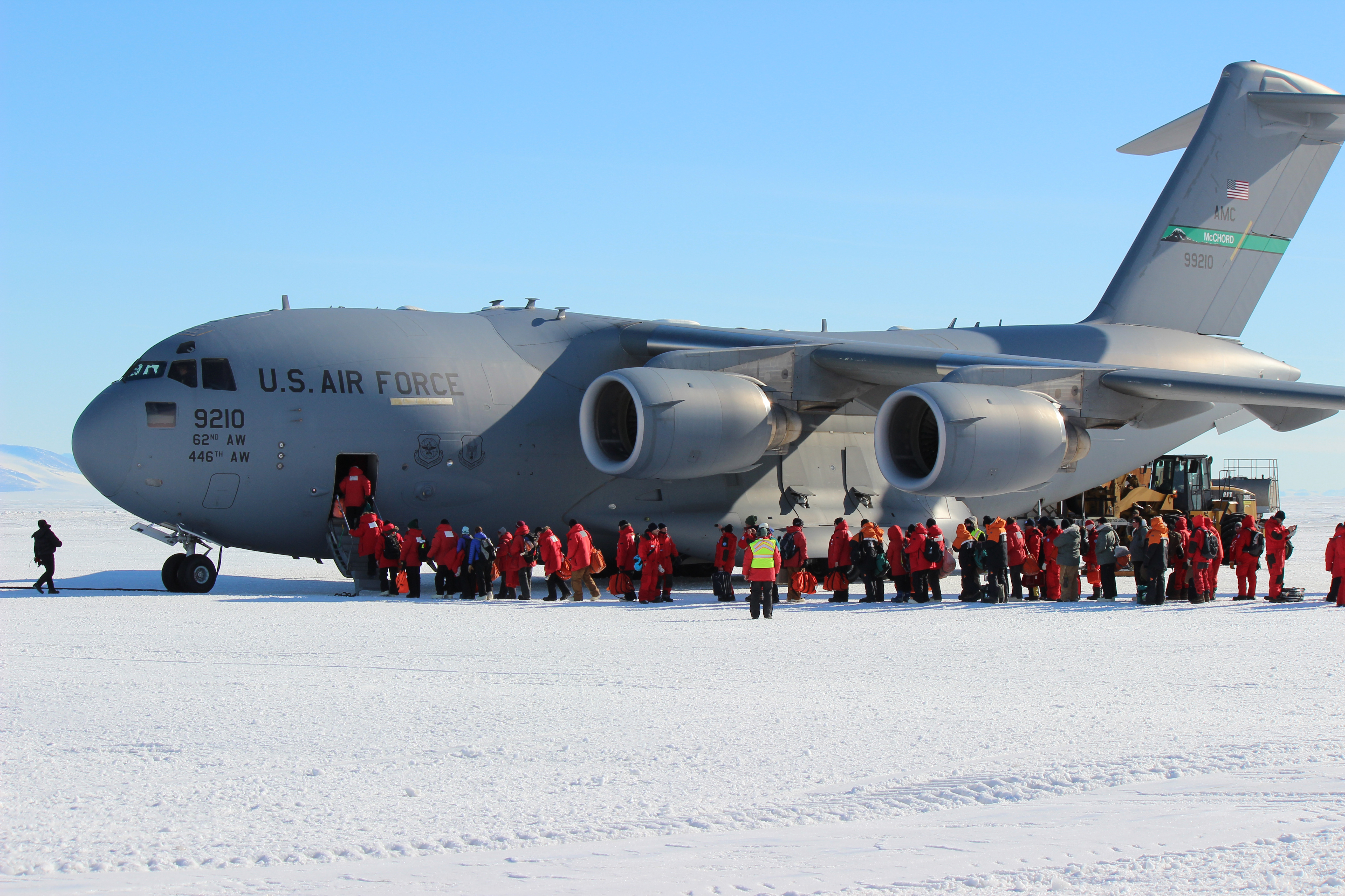 People in red coats boarding a jet.