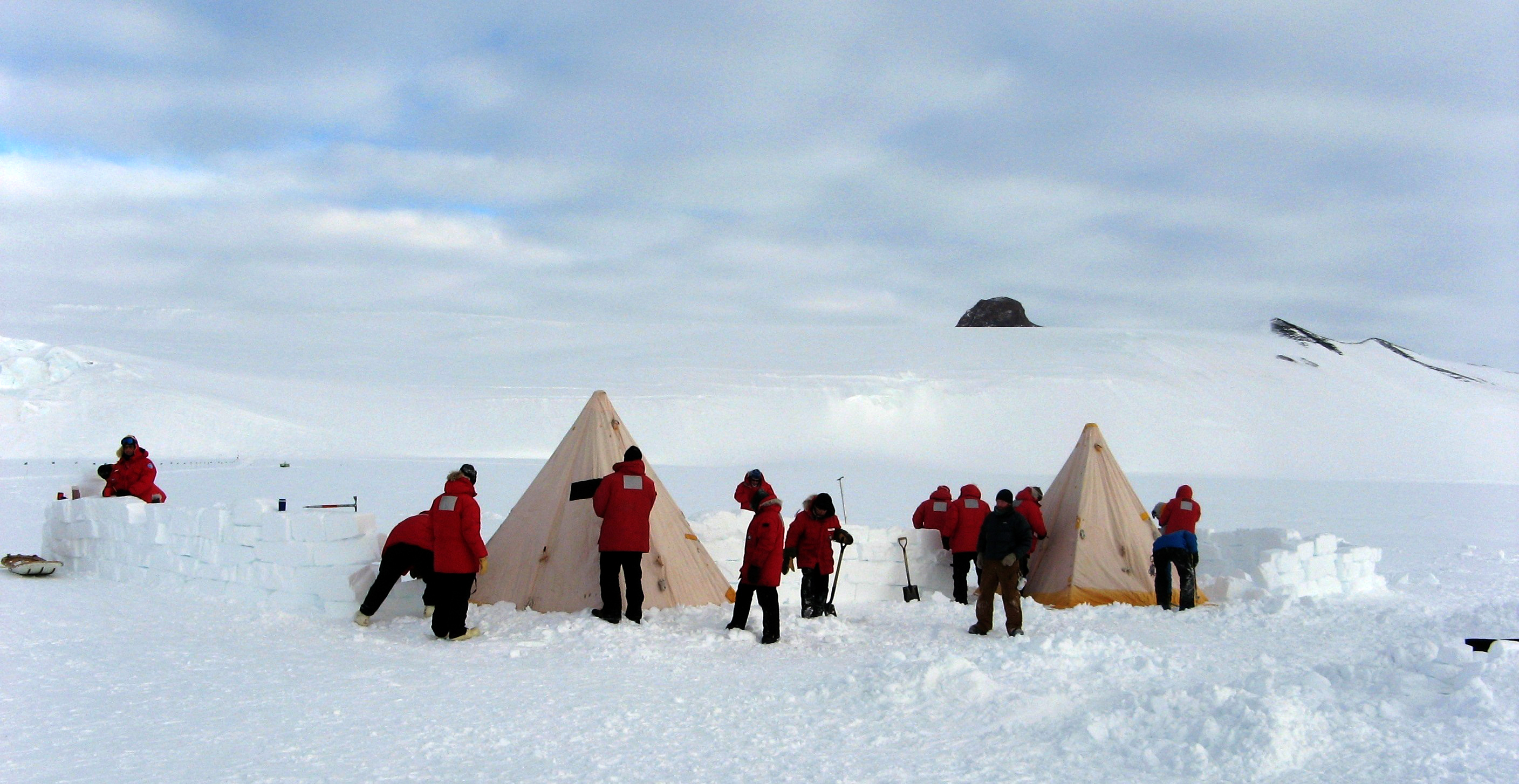 People set up tents in snow.