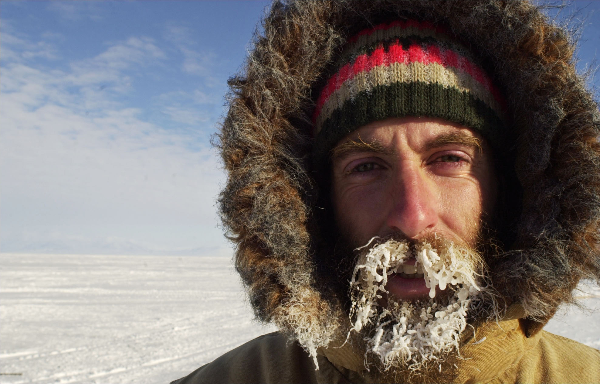 A man sports a frosty beard while standing outside.