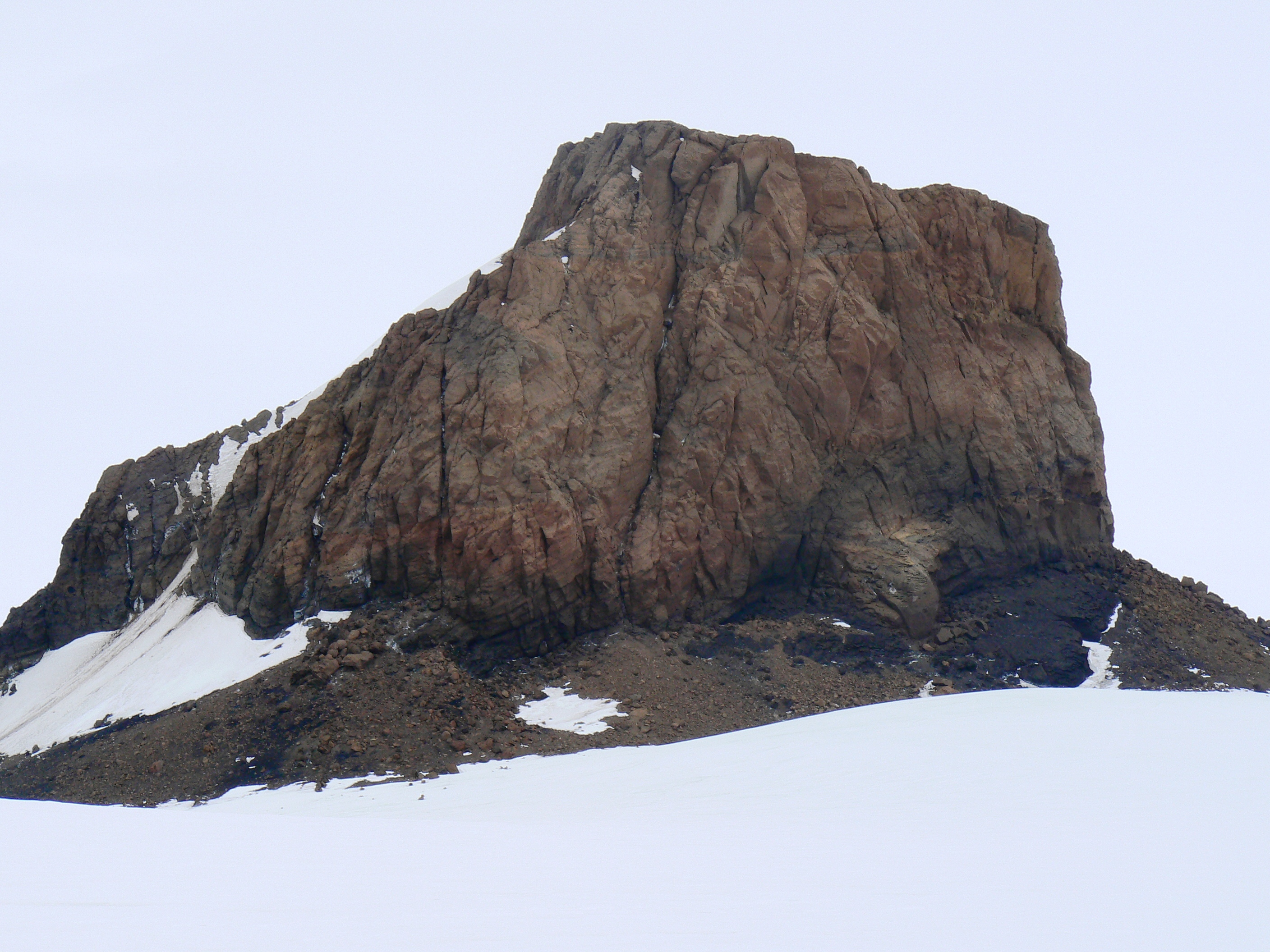 A large rock outcropping emerges from the snow.