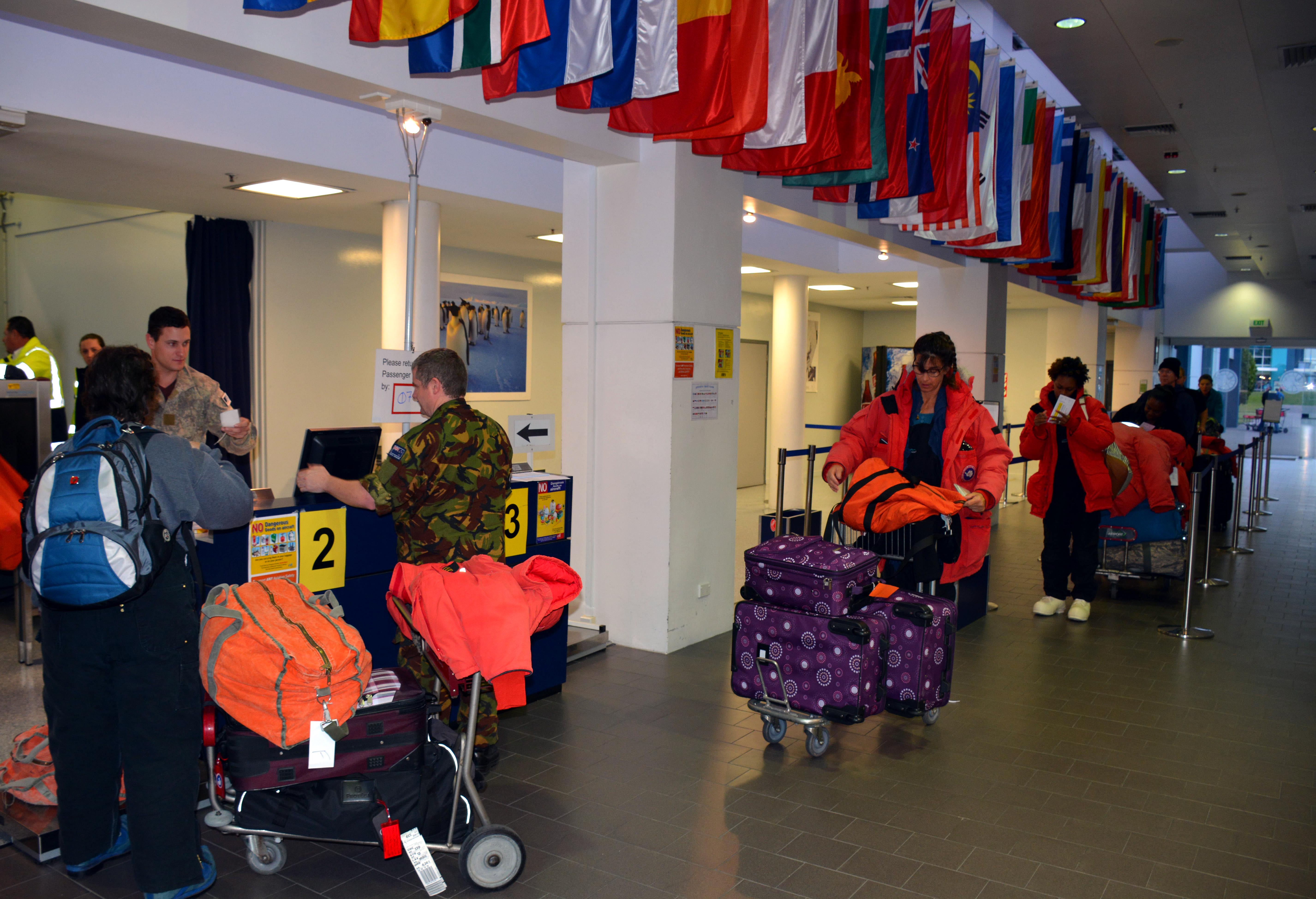 People with luggage check into an airport.