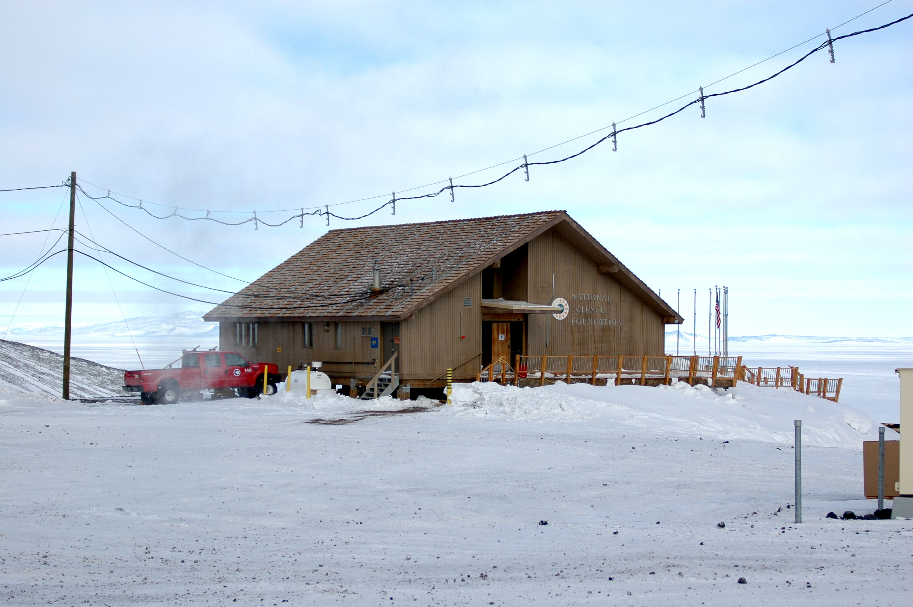 Snow surrounds a wood building.