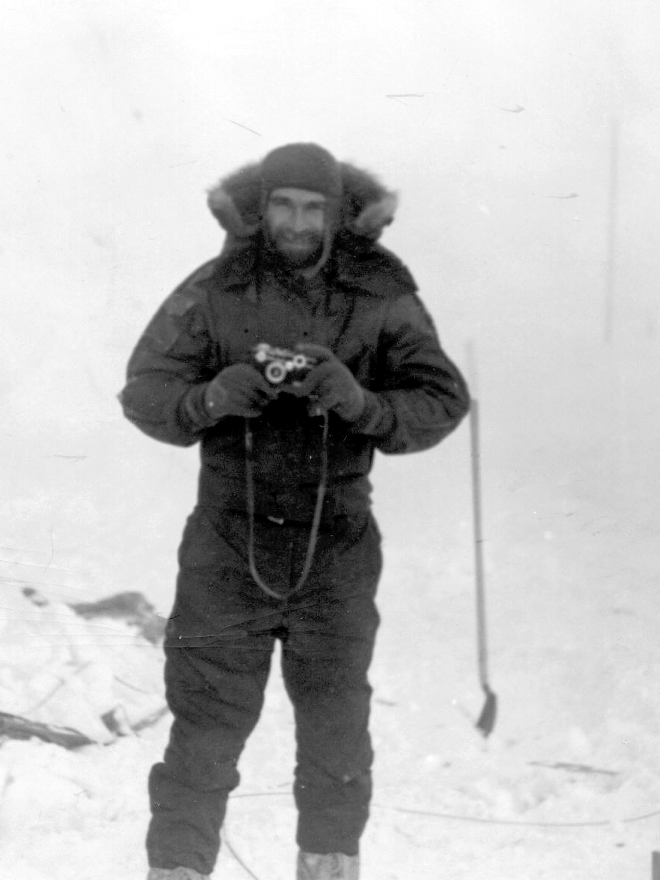 Man in winter clothing holds camera.