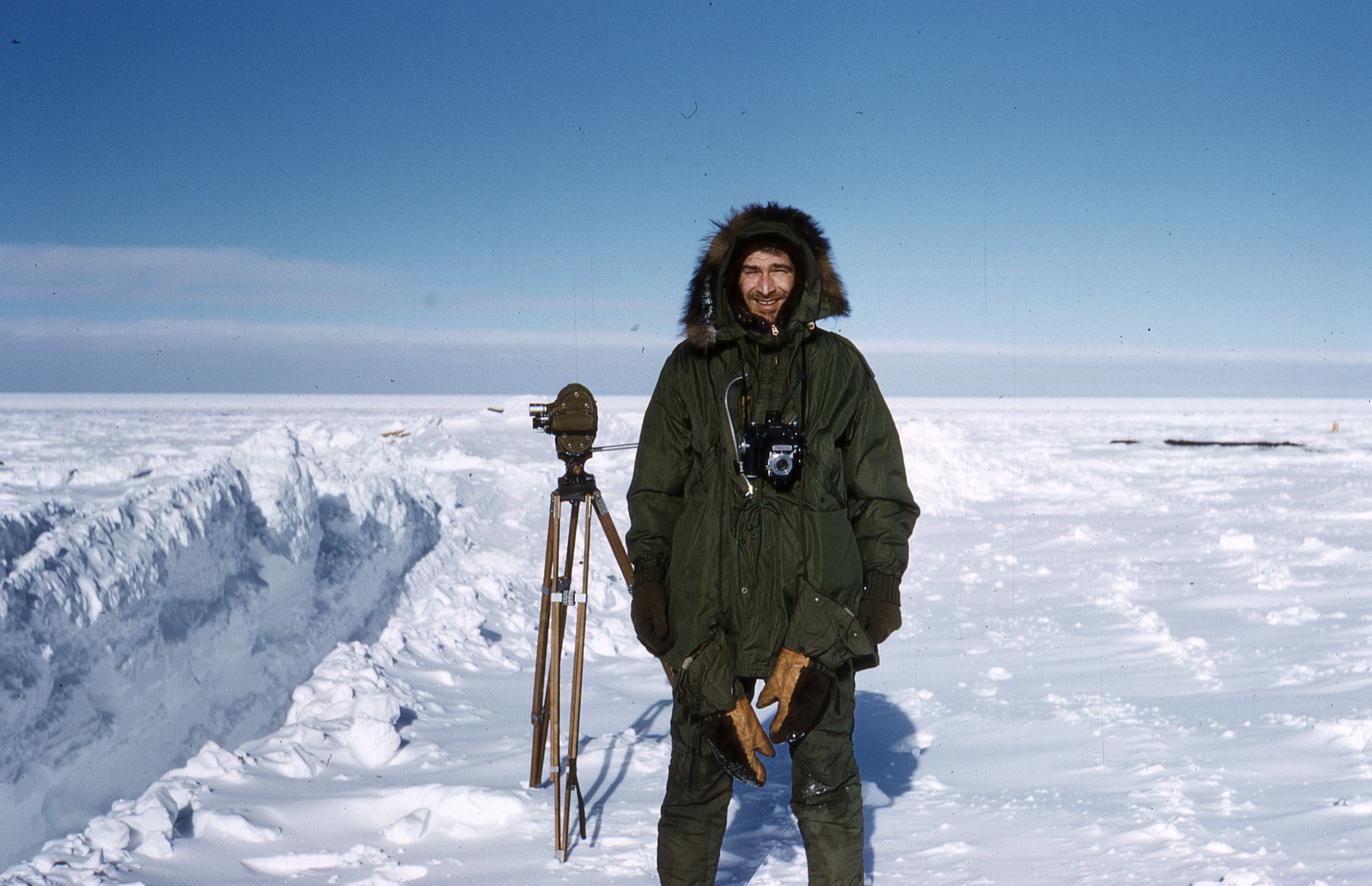 Man in winter clothing holds camera.