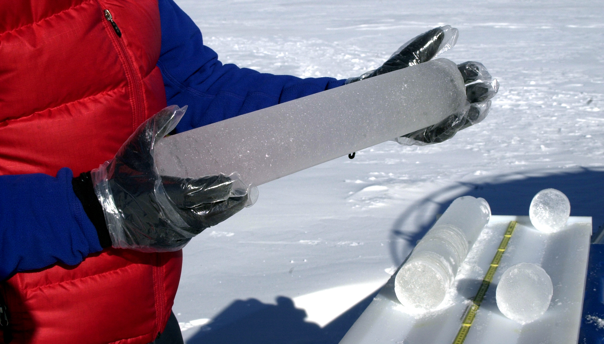 A person holds a length of ice core.