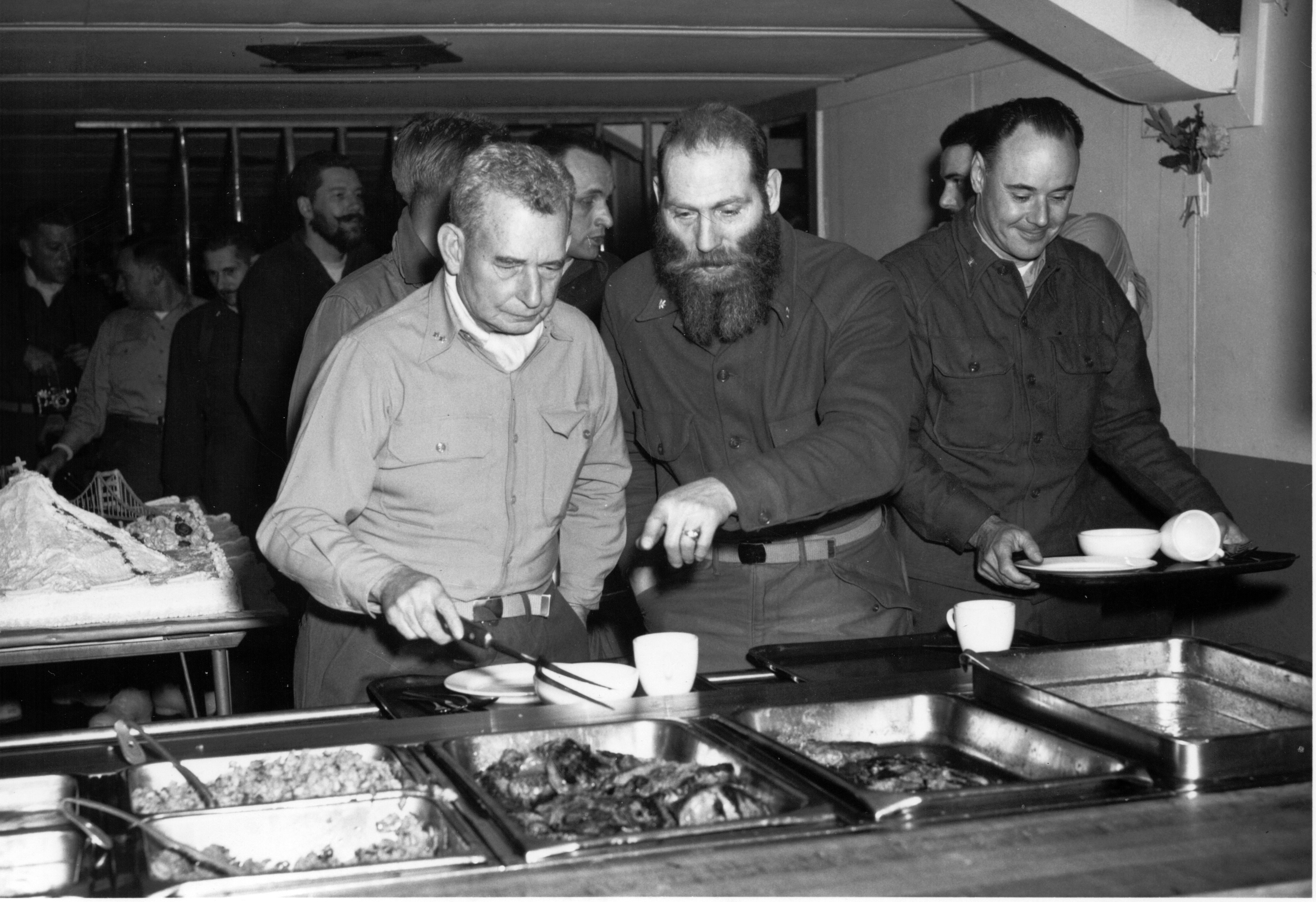 Men in a cafeteria food line.