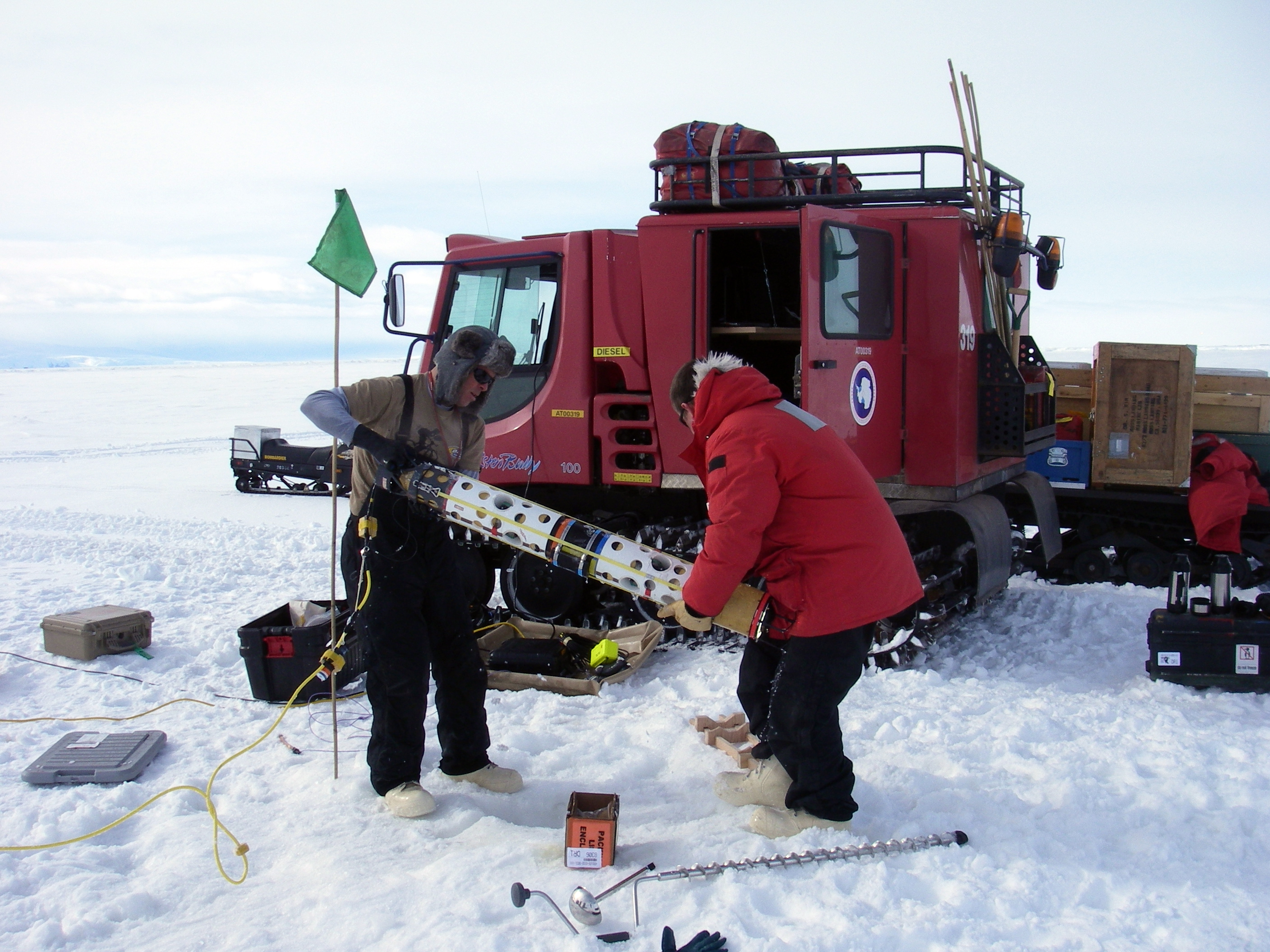 Two people working in the snow.