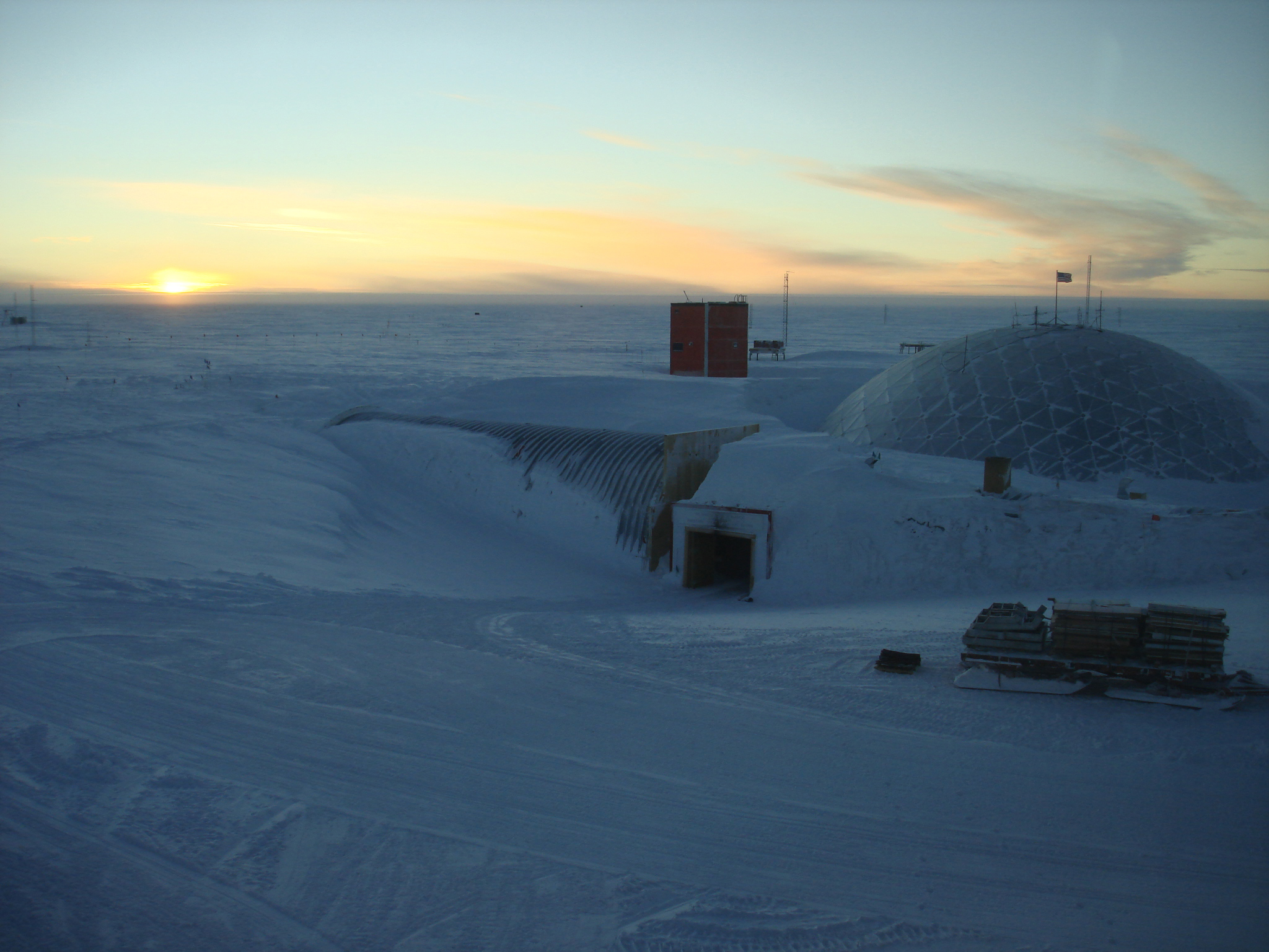 Sun sets on small complex of buildings.