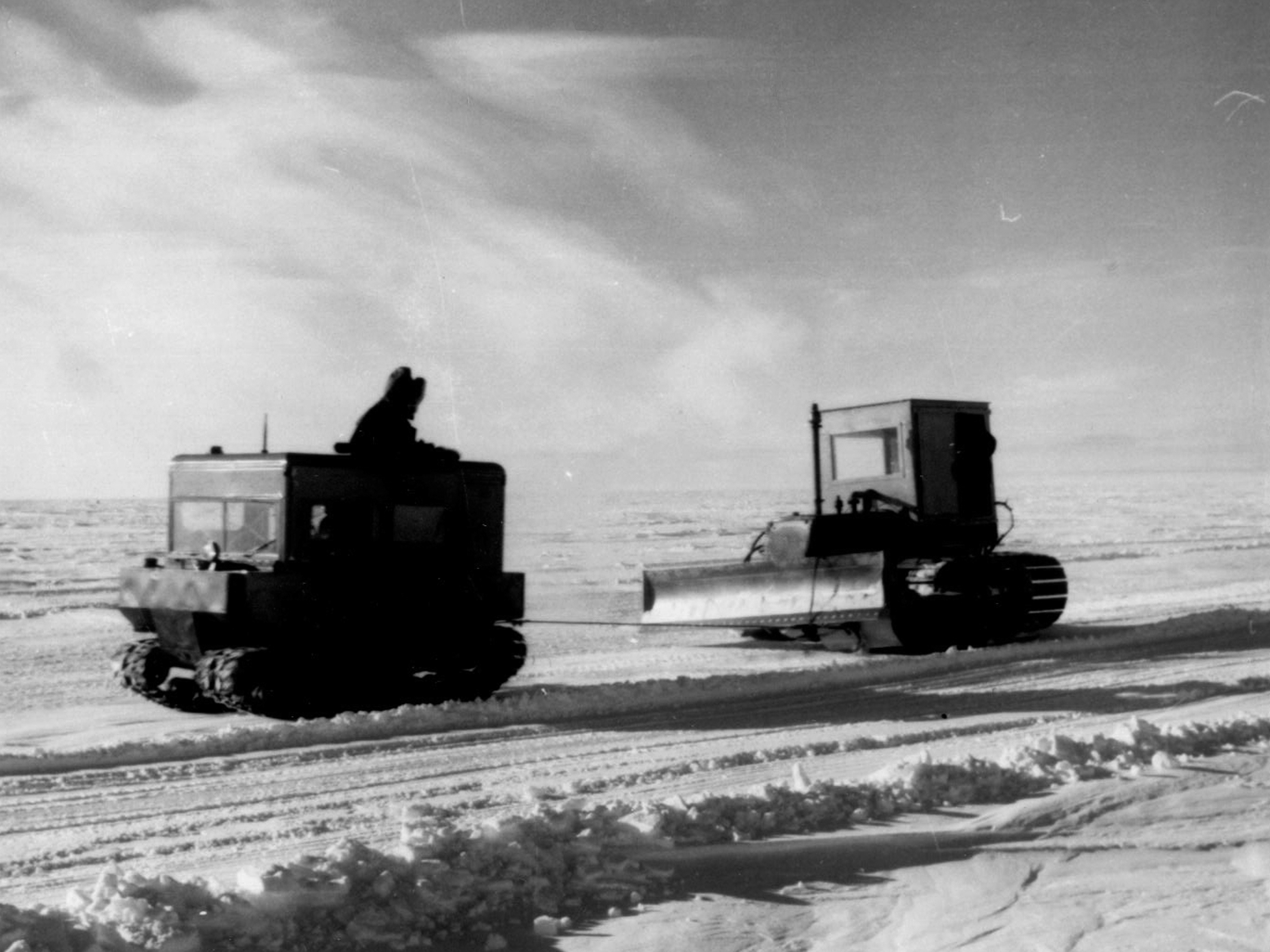 Two tracked vehicles on snow.