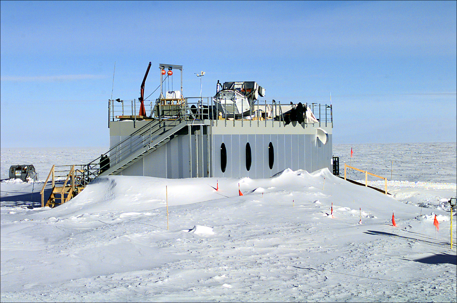 A building is partially covered by drifting snow.