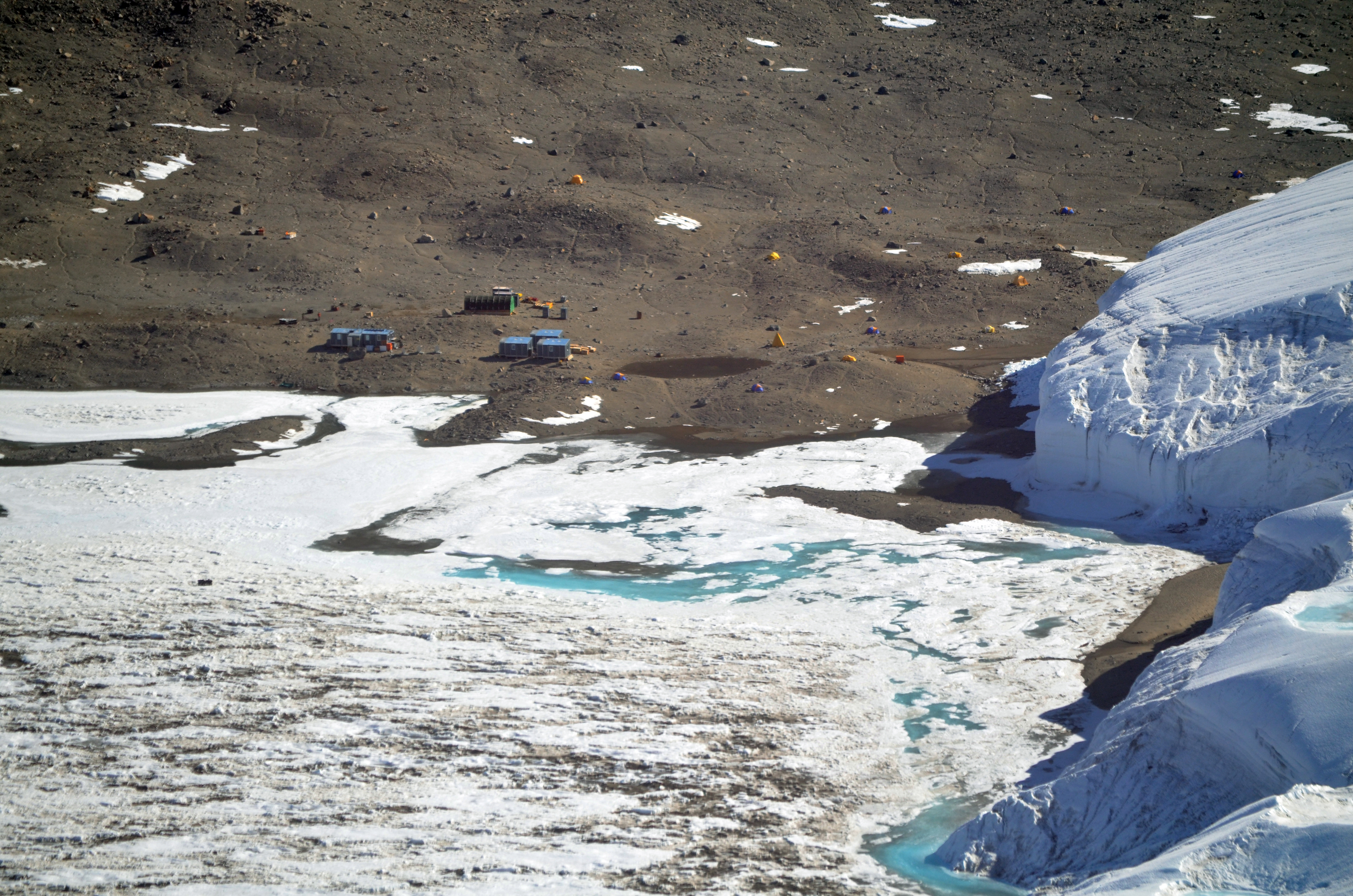 Small buildings sit near ice.