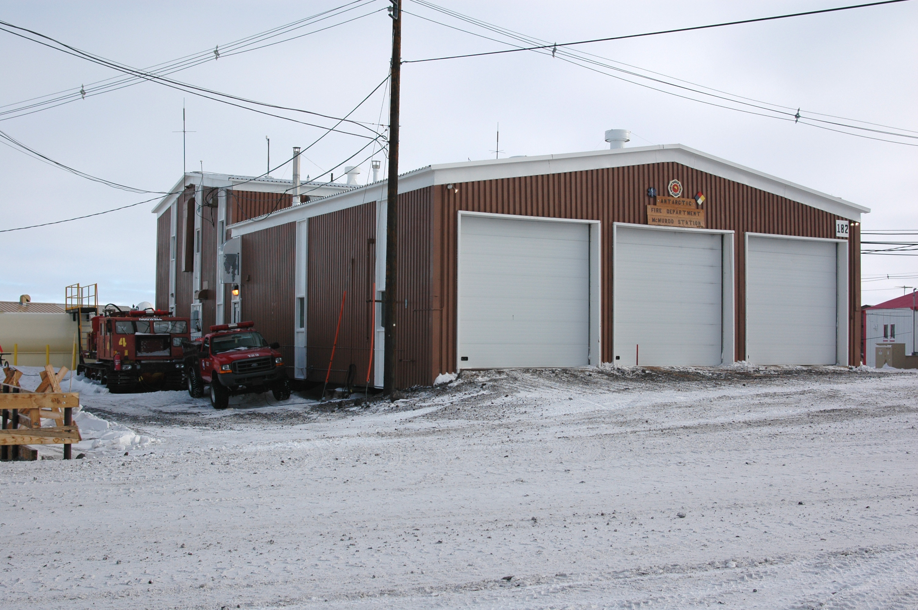 Snow covers a road in front of a building.