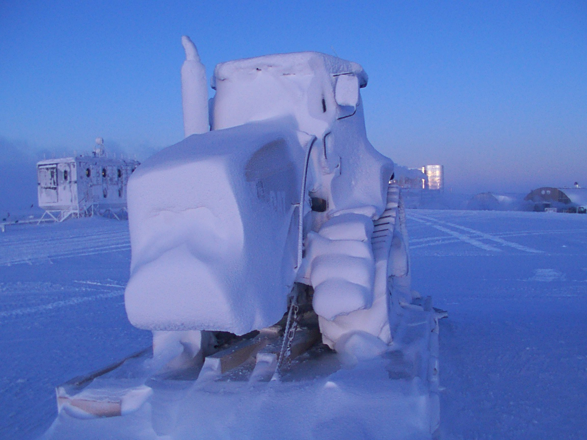 A tractor is encased with snow.