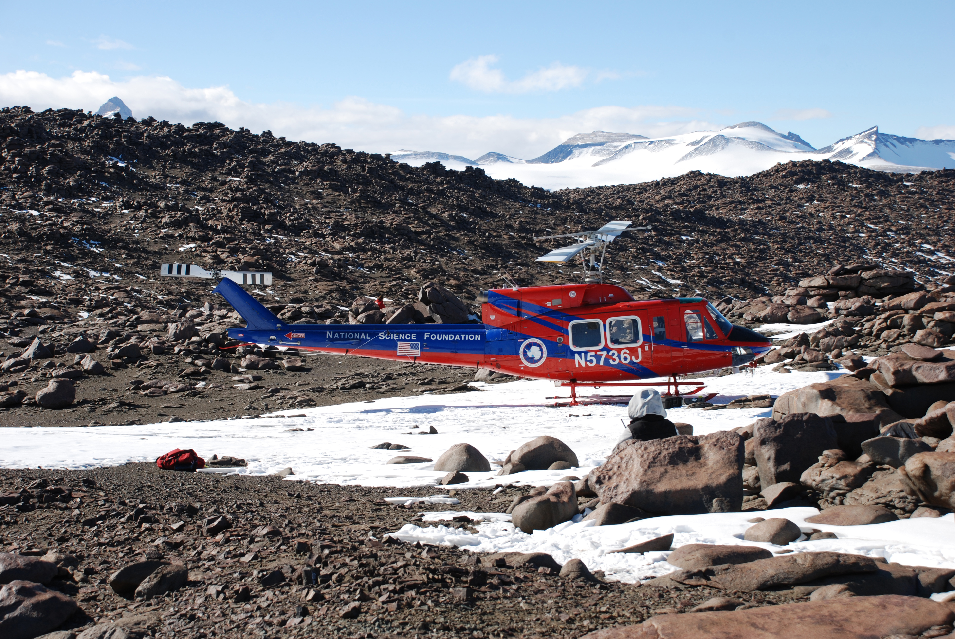 A helicopter sitting on rocky terrain.