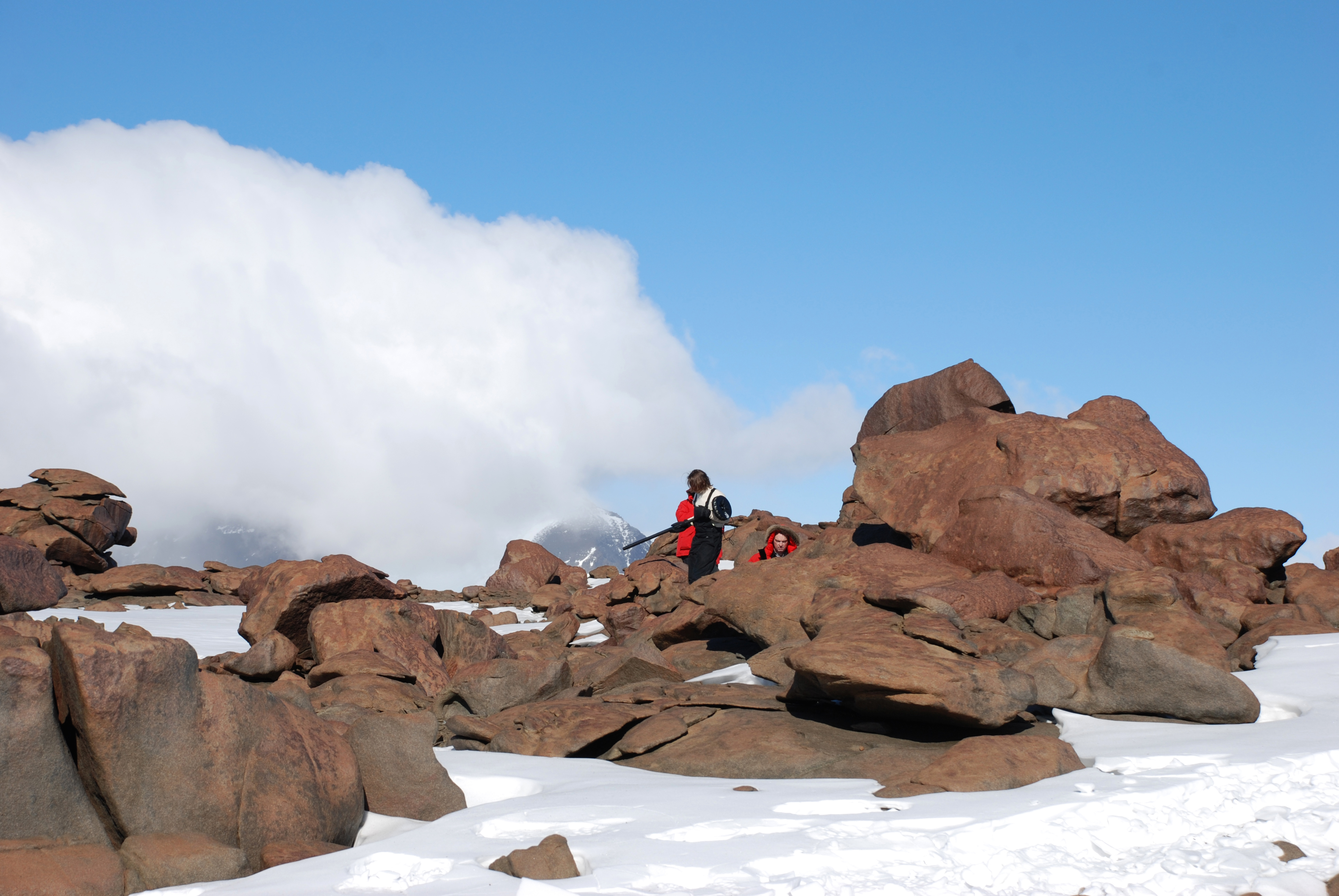 People walking amongst boulders.