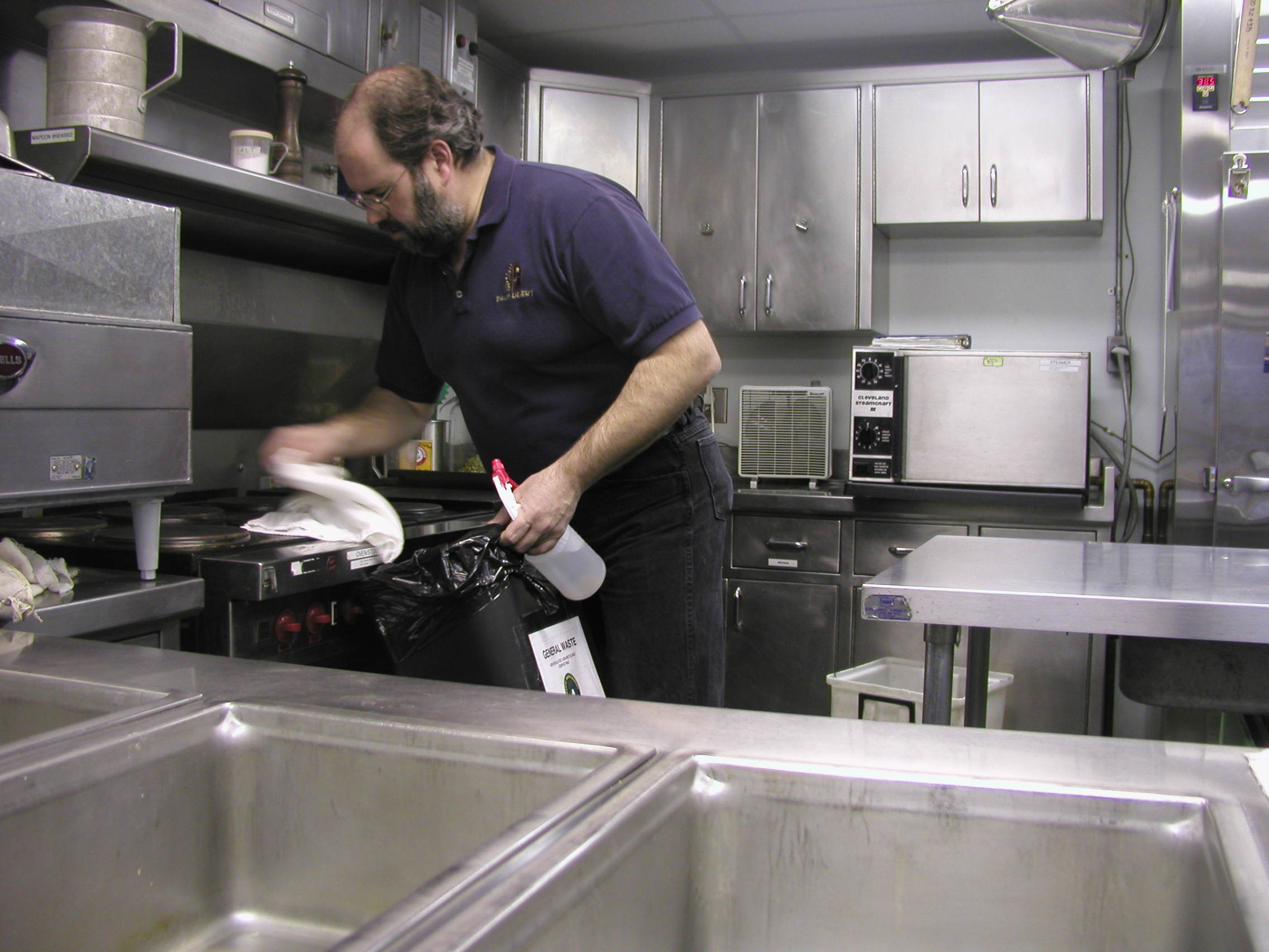 Man wiping stovetop.