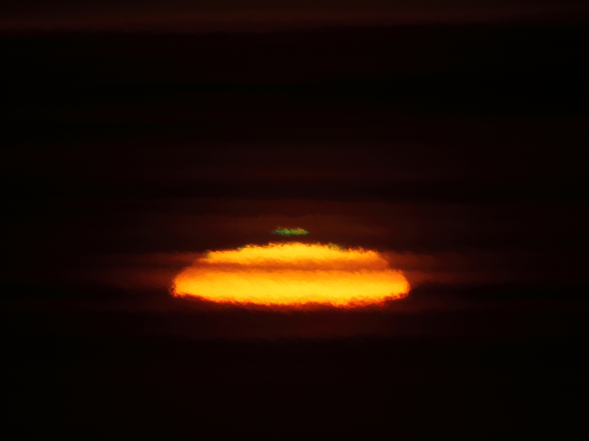 A green flash above a rising sun.