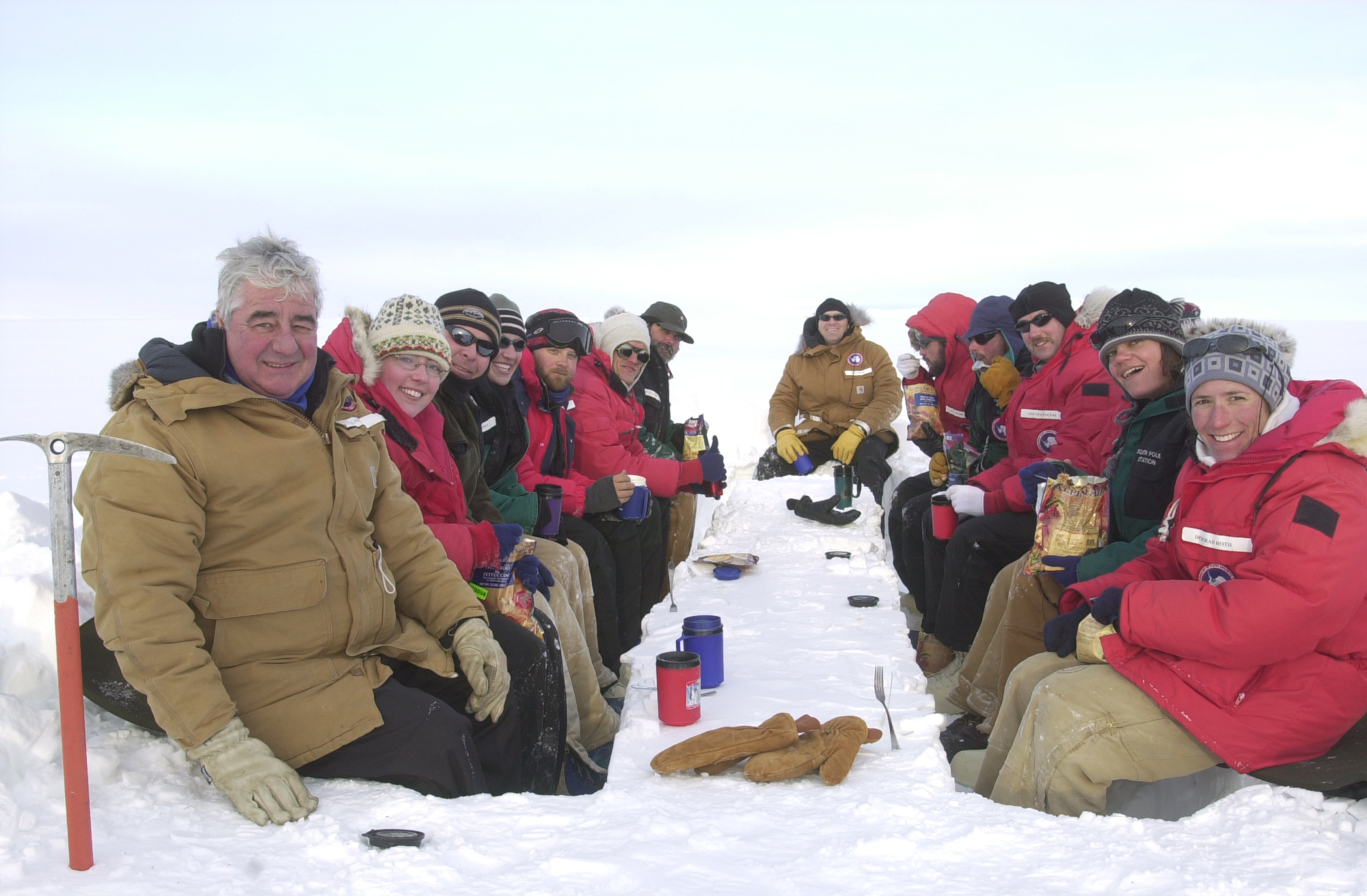 People eating around a table made of snow.