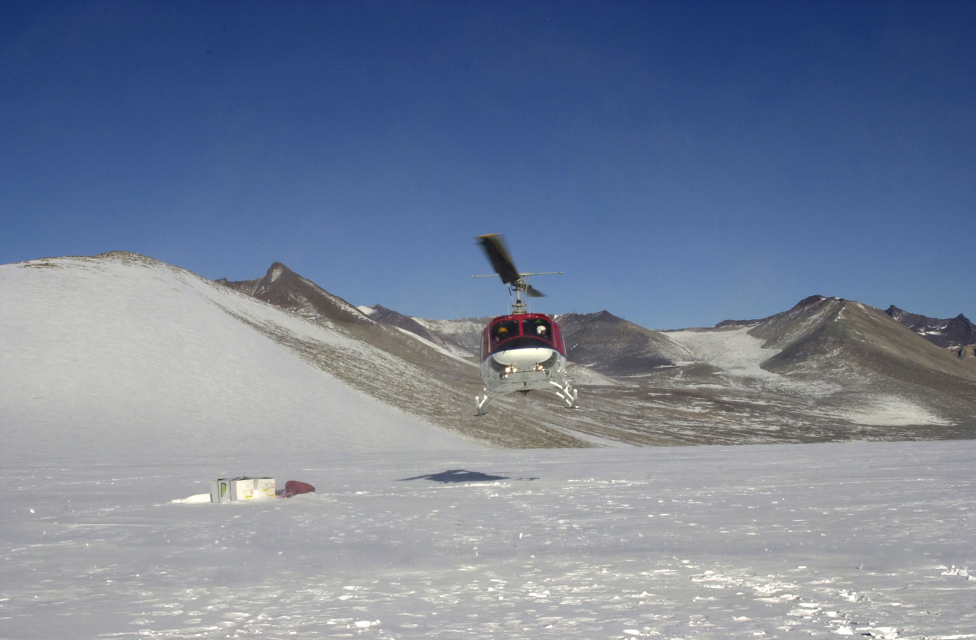 A helicopter flies a few feet off the ground.