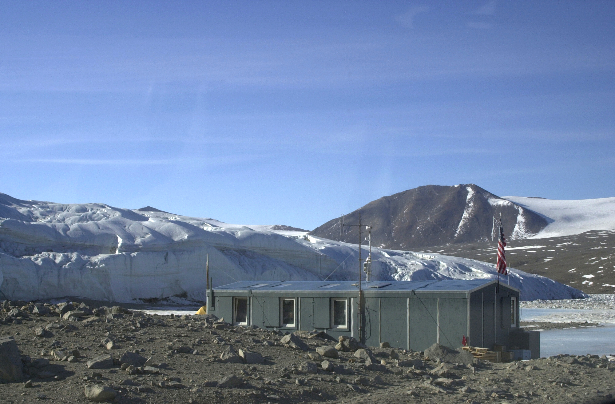 A building sits among rocks and snow.