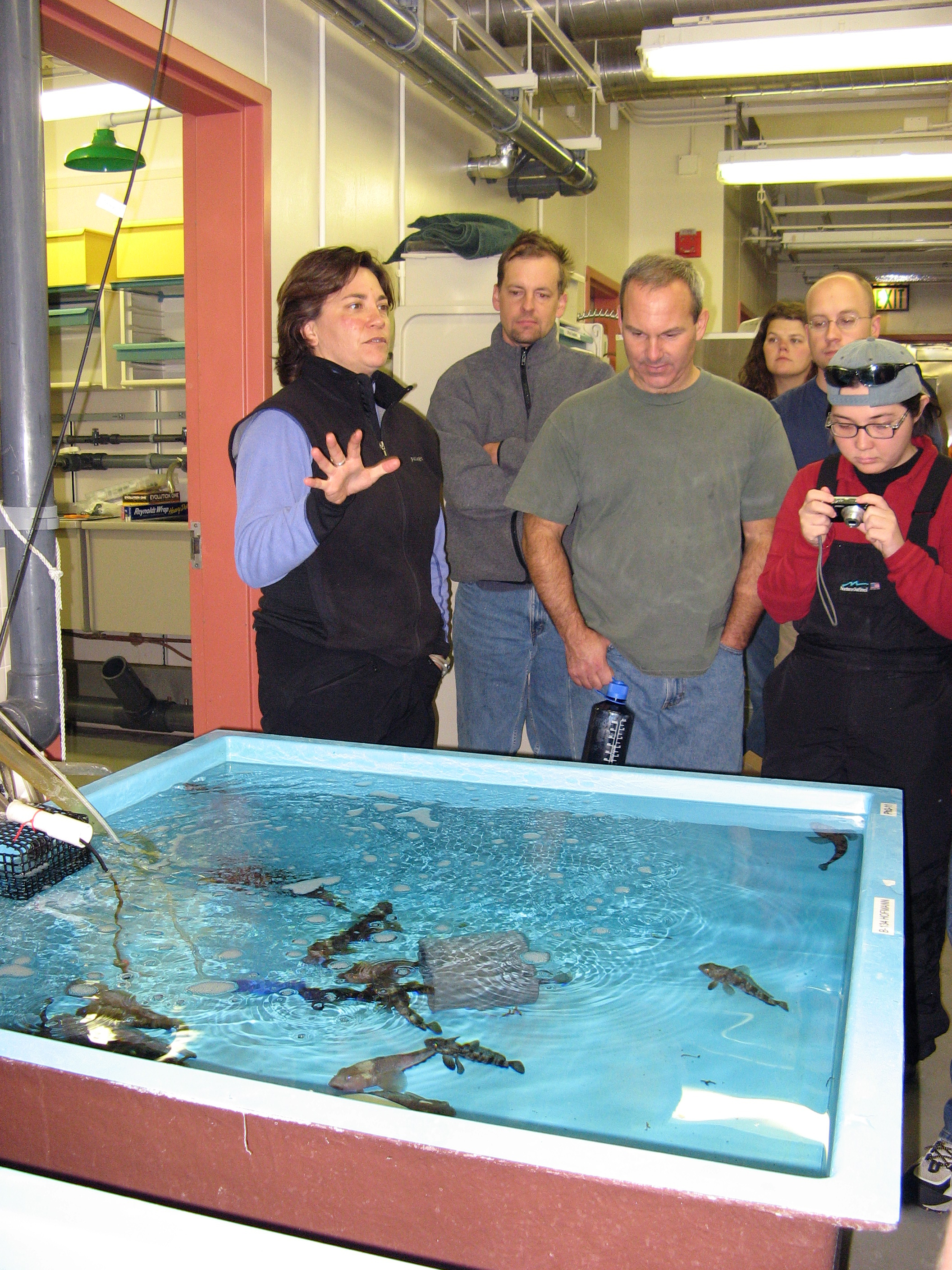 Group of people next to an aquarium.