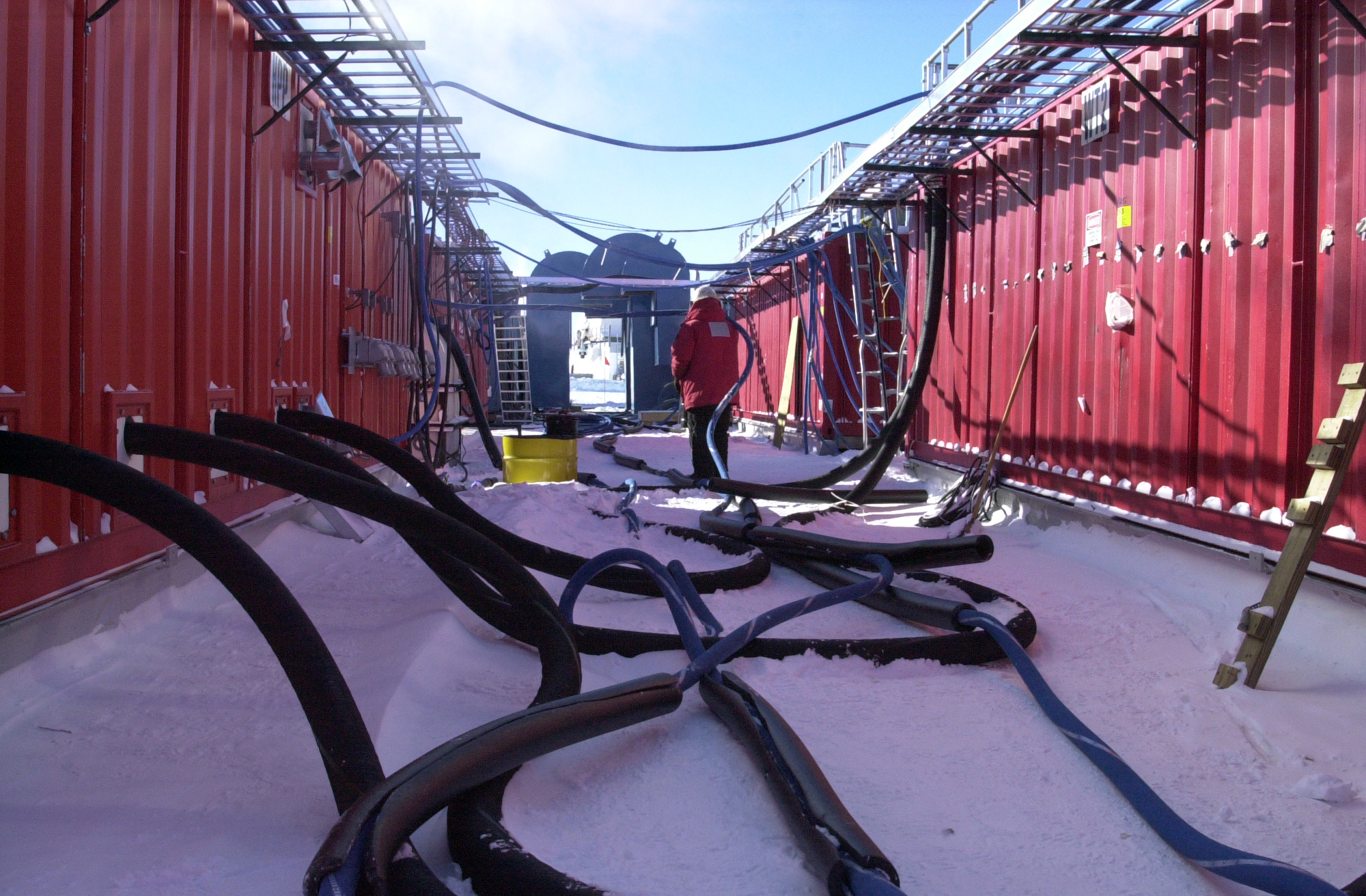 A person, hoses, red walls.