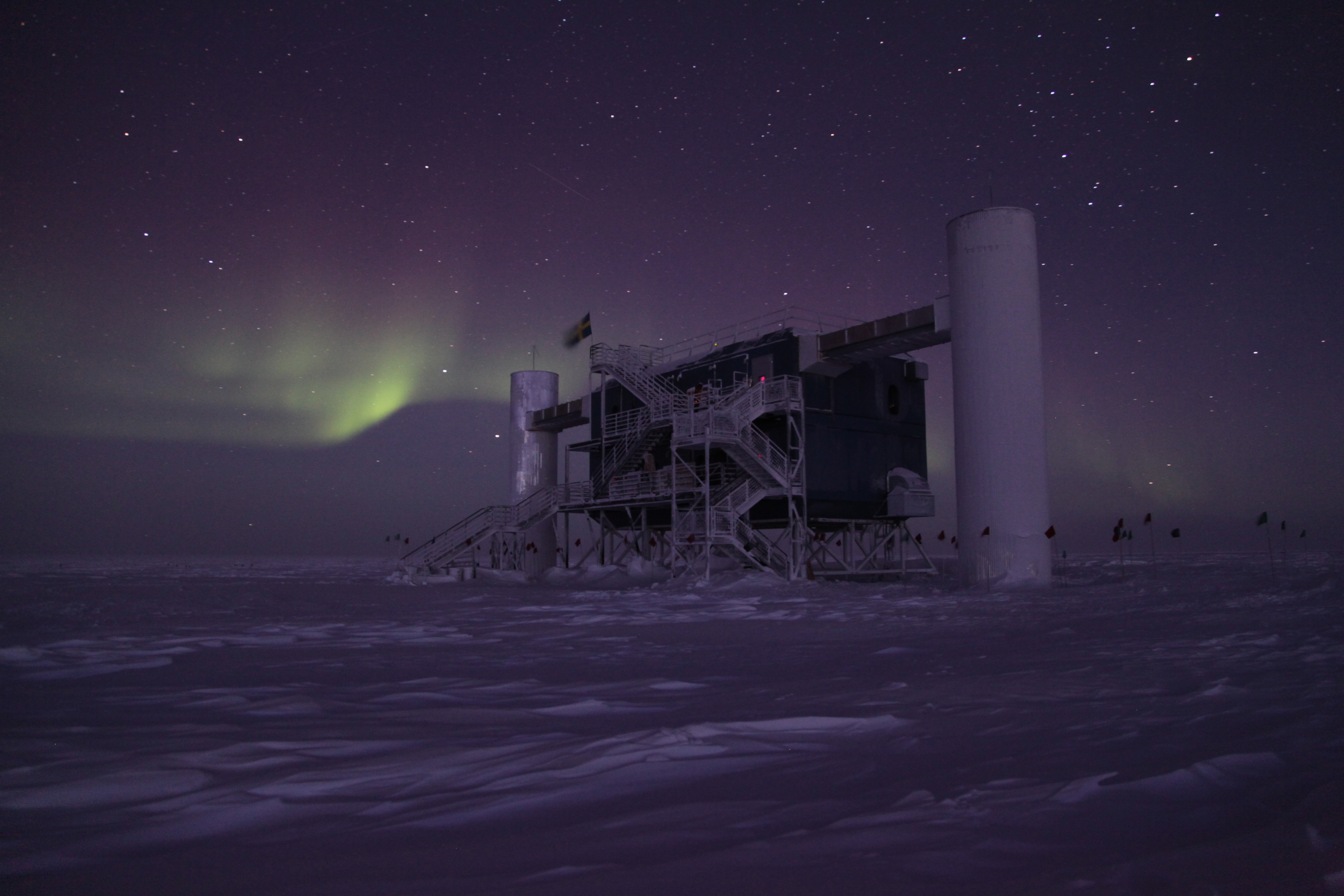 A night photo of auroras over a building.