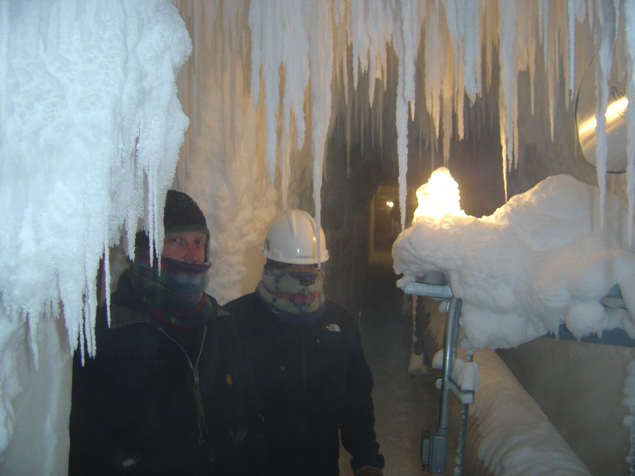 Two people in ice tunnel.