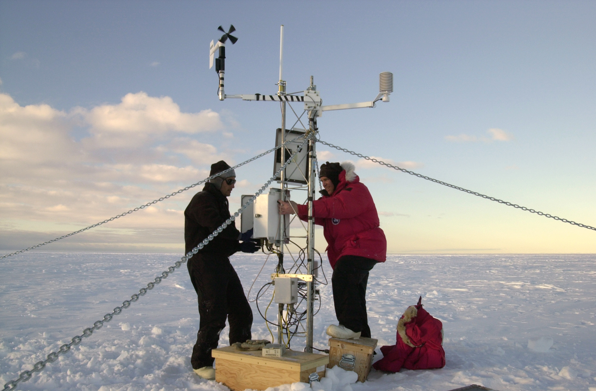 Two people work on a short receiving tower.  