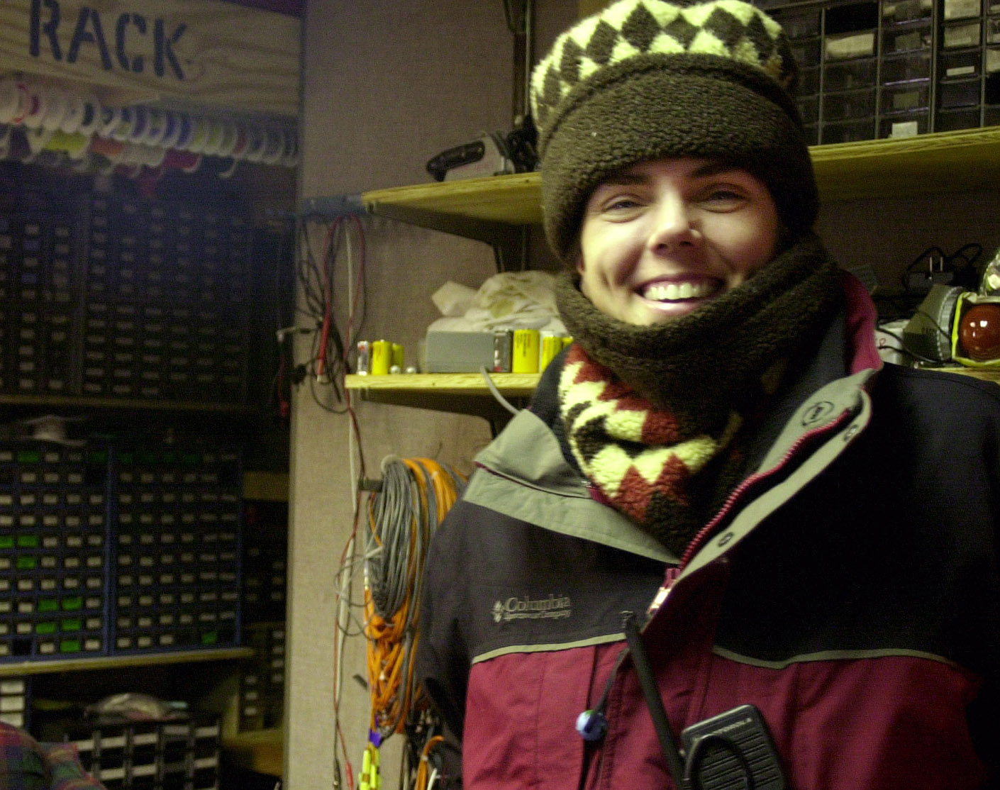 A woman with coat, scarf around her neck, and stocking cap.