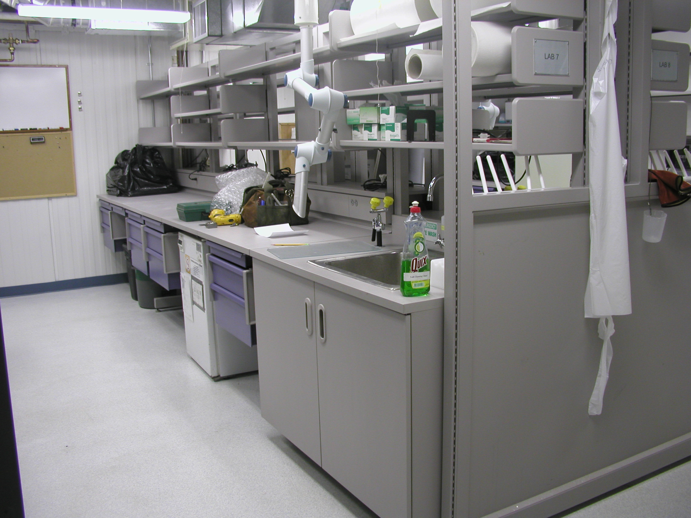 Counters, drawers, sink and empty shelves.