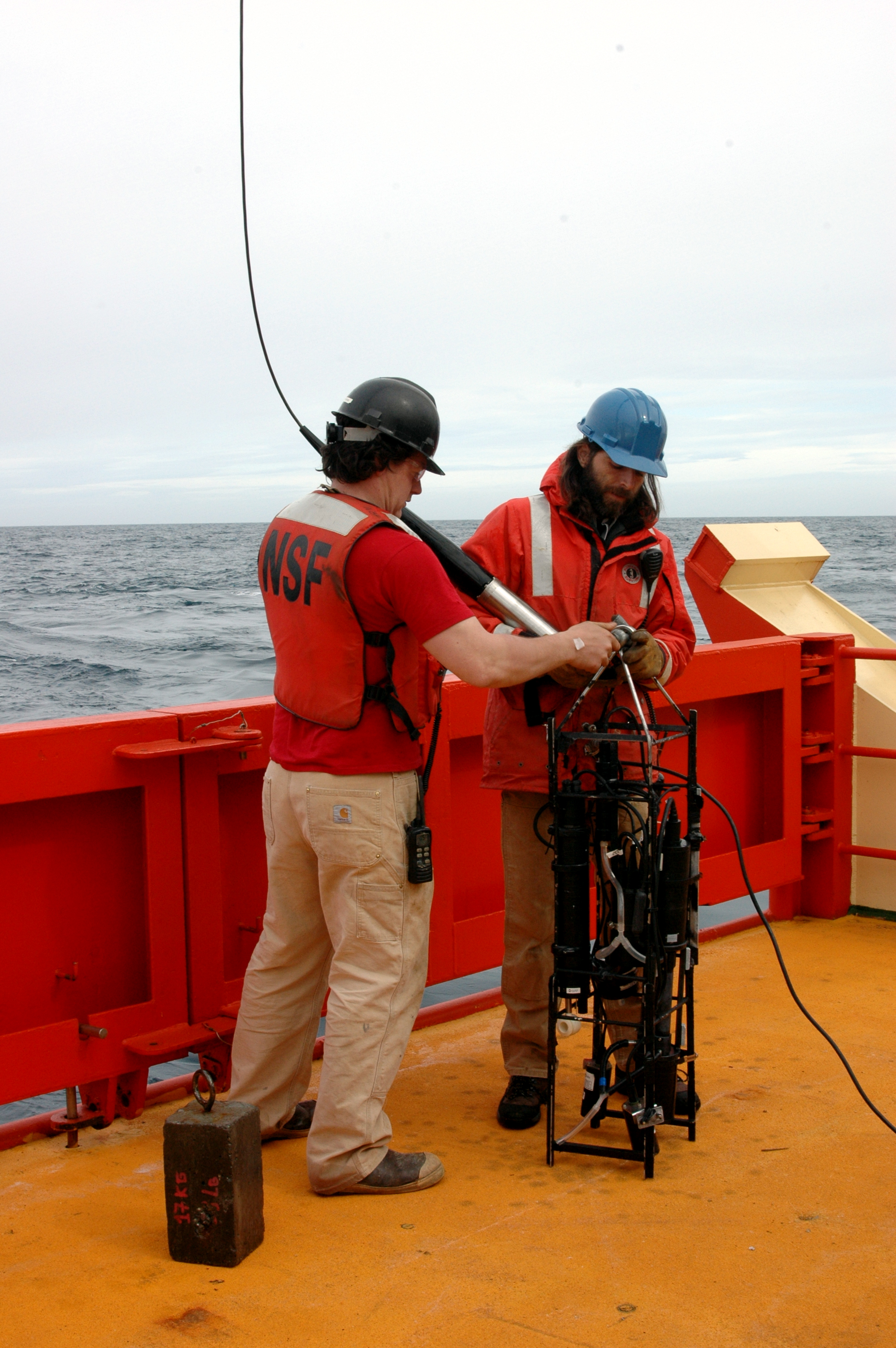 Two men working on a ship.