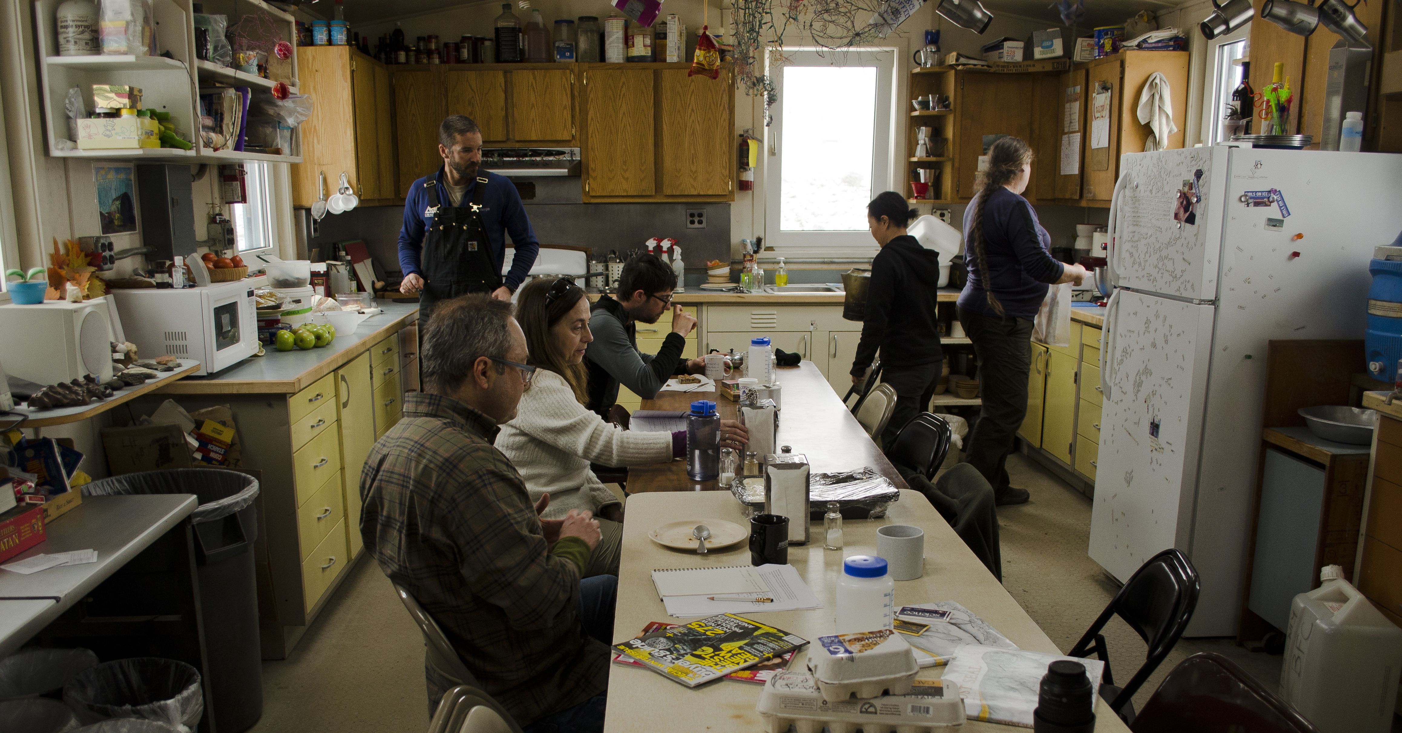 People gather around a kitchen table.