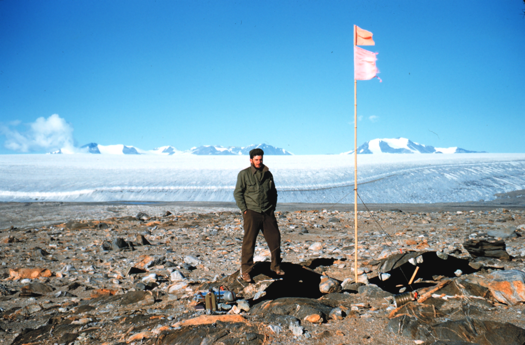 A man standing by a flag pole.