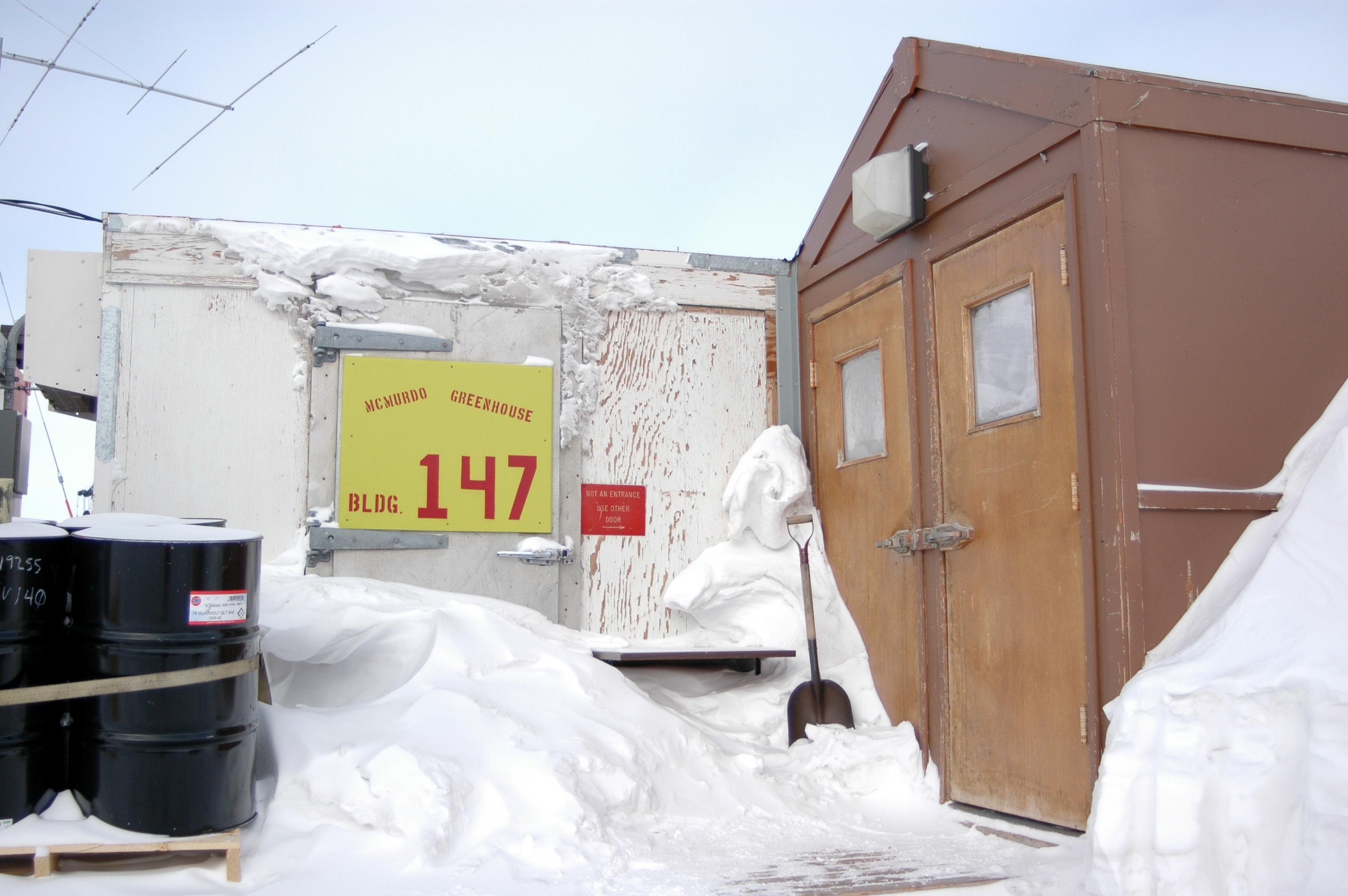 Snow covers the doors of a building.