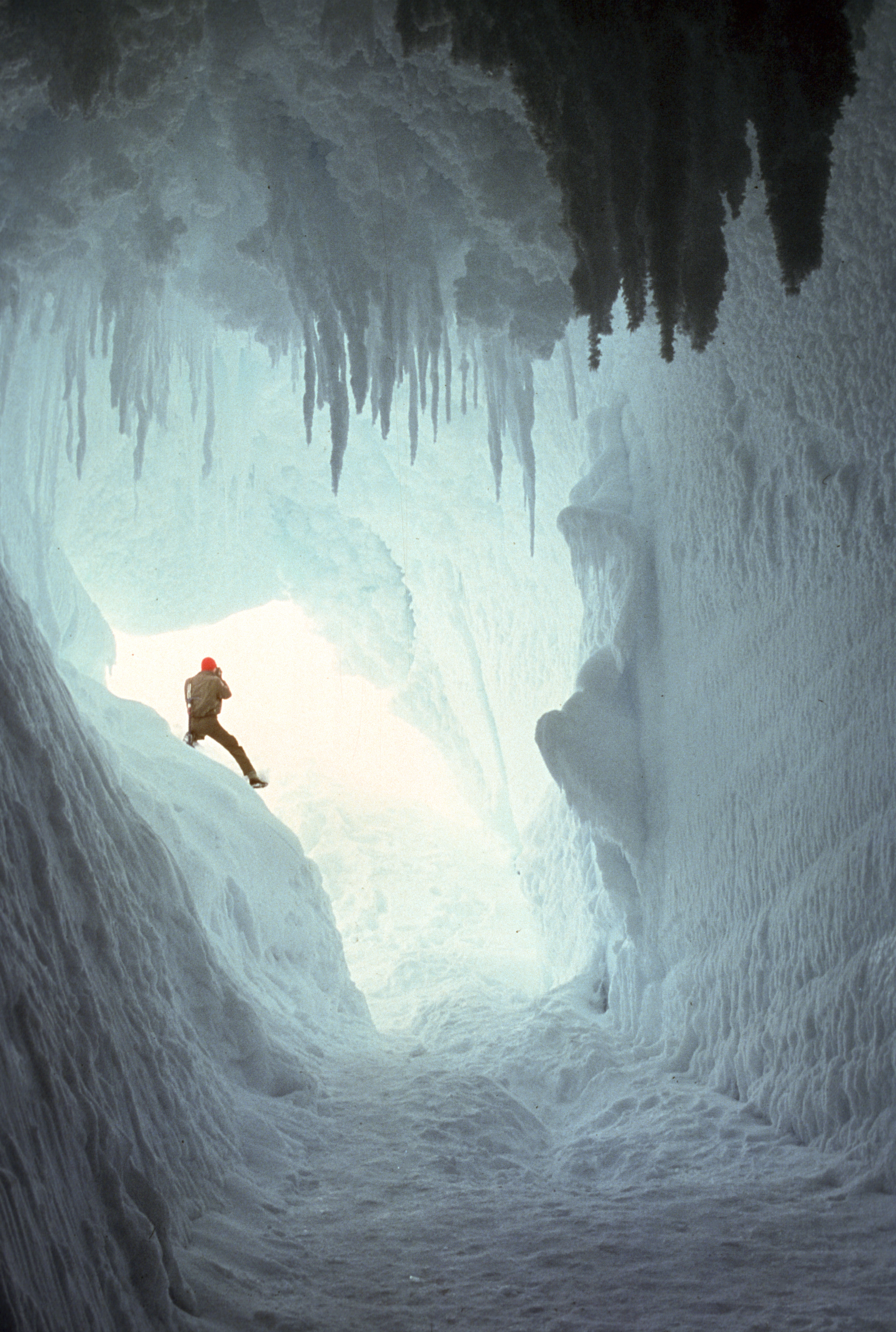 A person inside a vast ice cave.