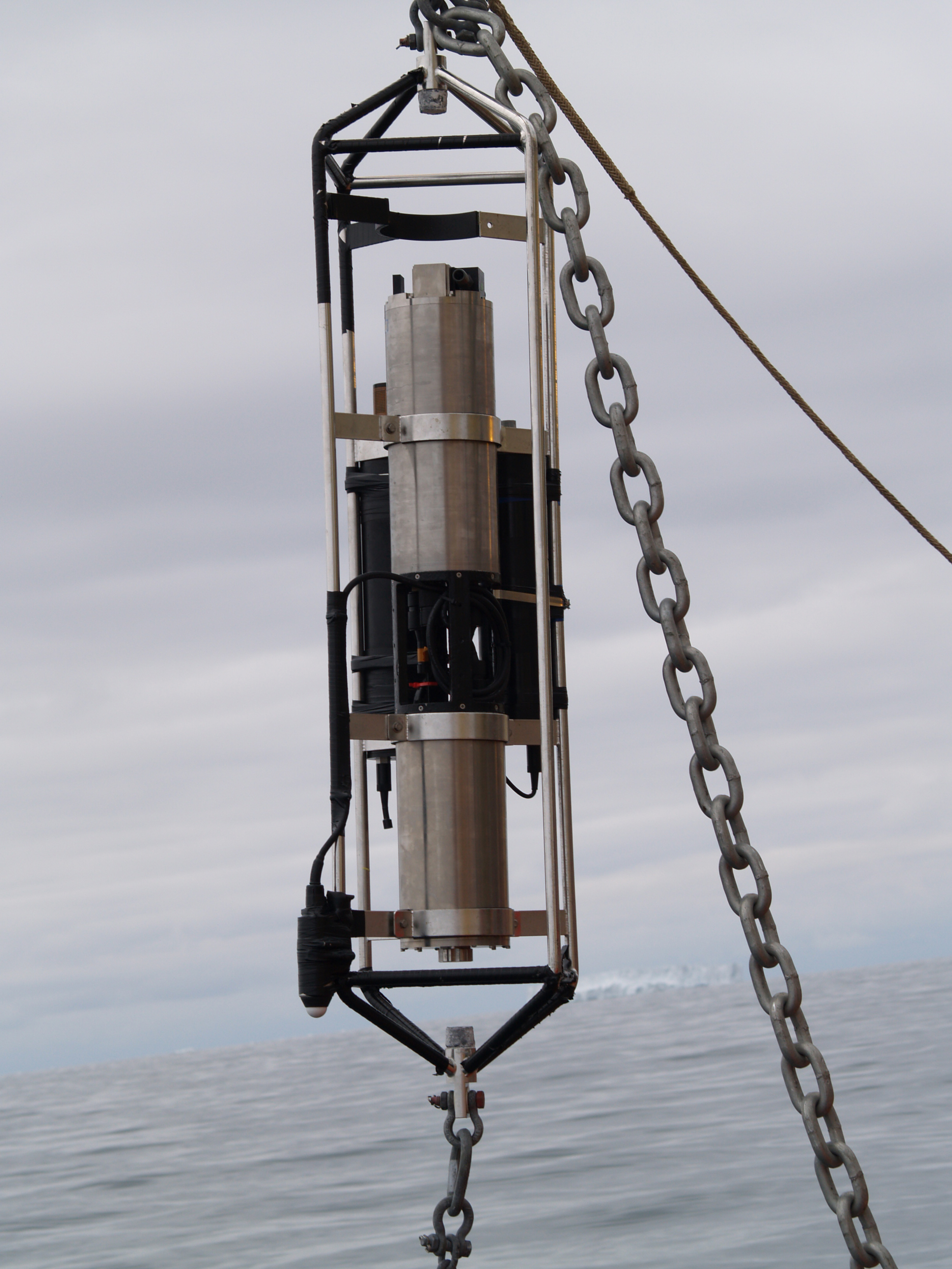 A large instrument hangs above the ocean.