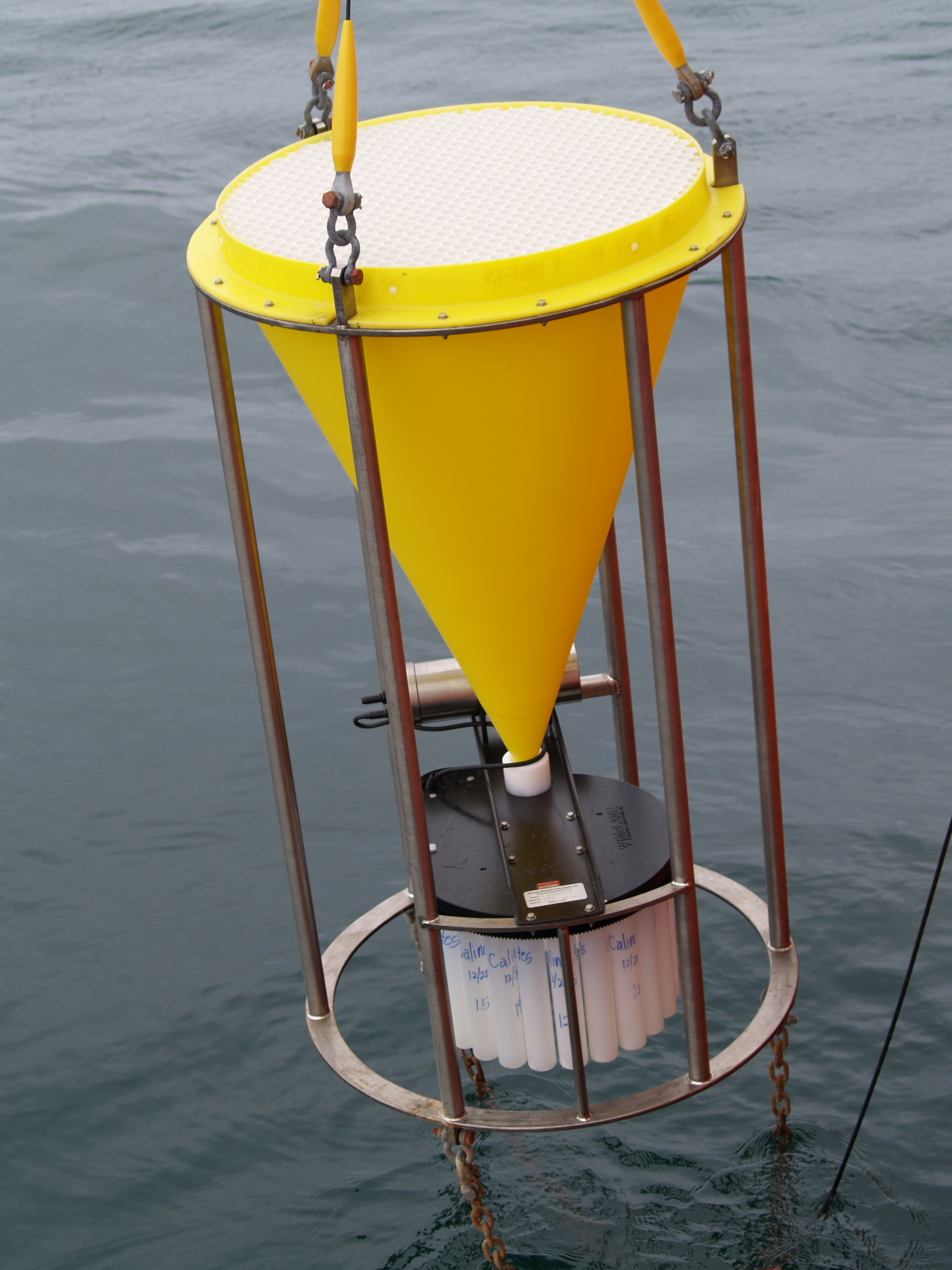 A large instrument is suspended over the ocean.