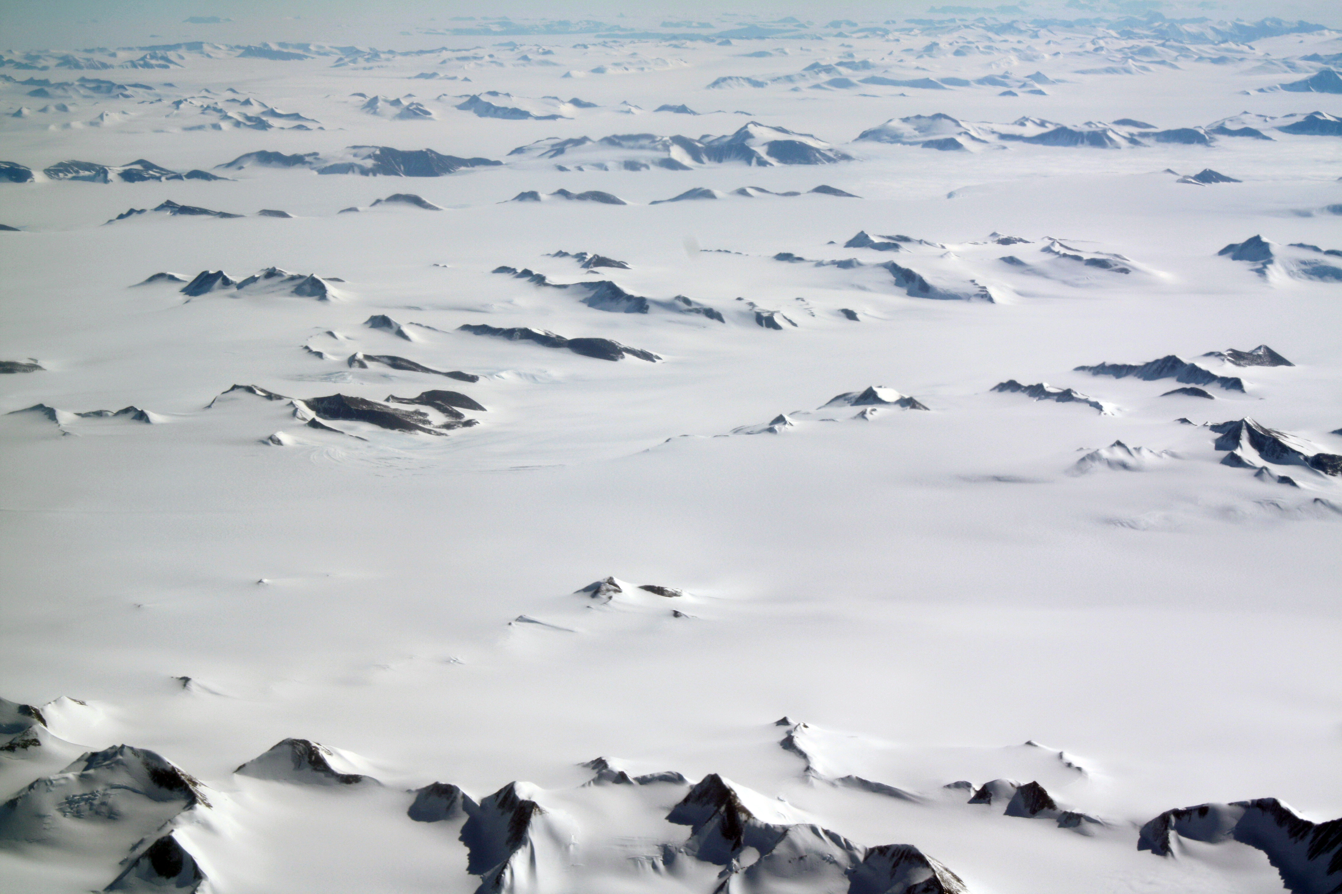 Aerial view of snow buried mountains.